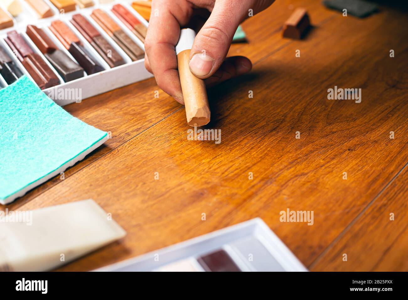 master chiude un graffio con una matita di cera. Restauro laminato e parquet.  Riparazione di una superficie in legno Foto stock - Alamy