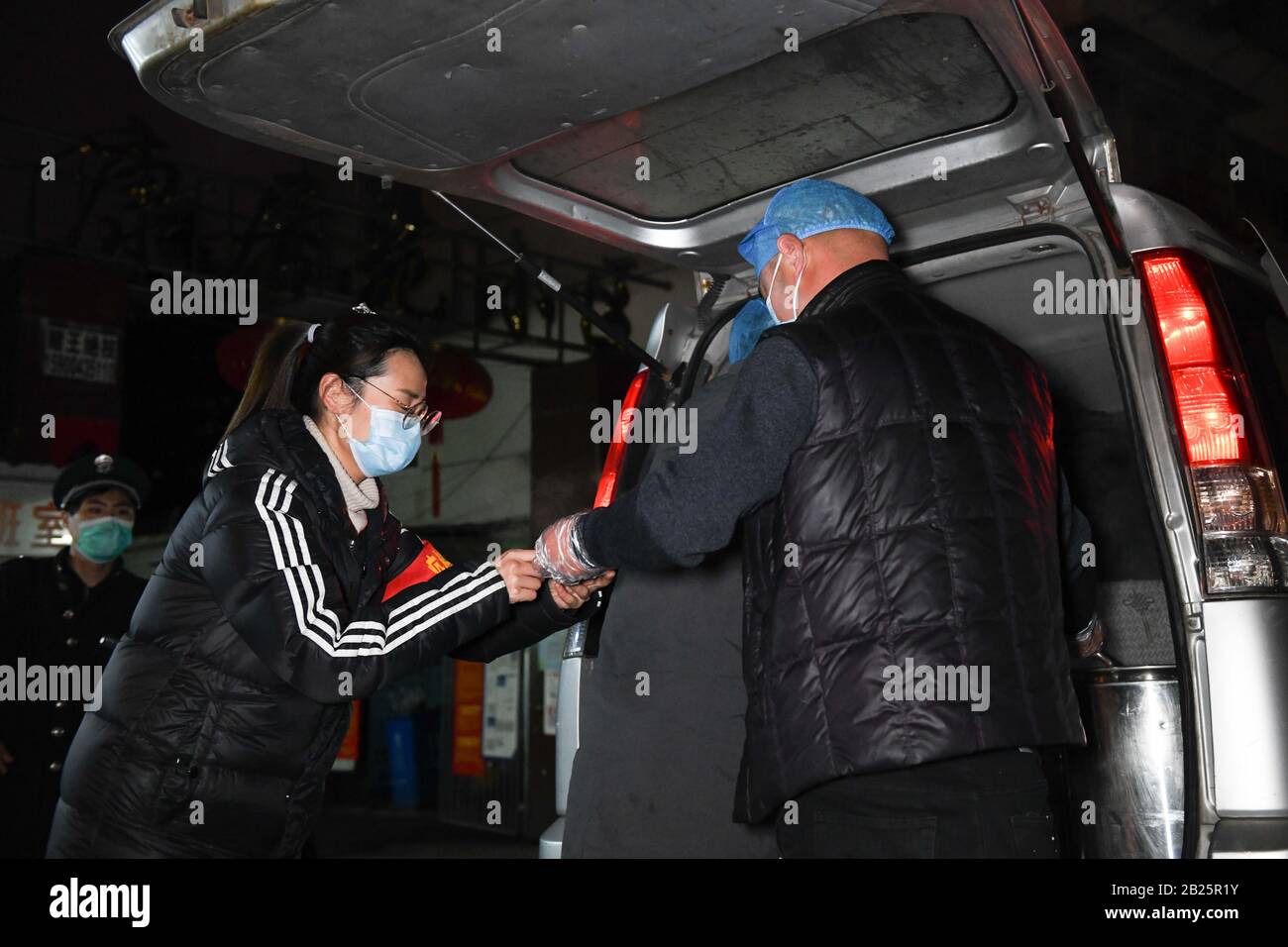 Anhui, Cina. 29th Feb, 2020. Zhang Shiyang (R), nipote di Zhang Lanying, offre un pasto gratuito ad un operaio della comunità nel distretto di Shushan di Hefei, nella provincia di Anhui nella Cina orientale, 29 febbraio 2020. Zhang Lanying, un residente di 70 anni nel distretto Shushan di Hefei, offre pasti gratuiti per i lavoratori della comunità che soggiornano di notte per la prevenzione delle epidemie. Dal Febbraio: Credito Xinhua/Alamy Live News Foto Stock