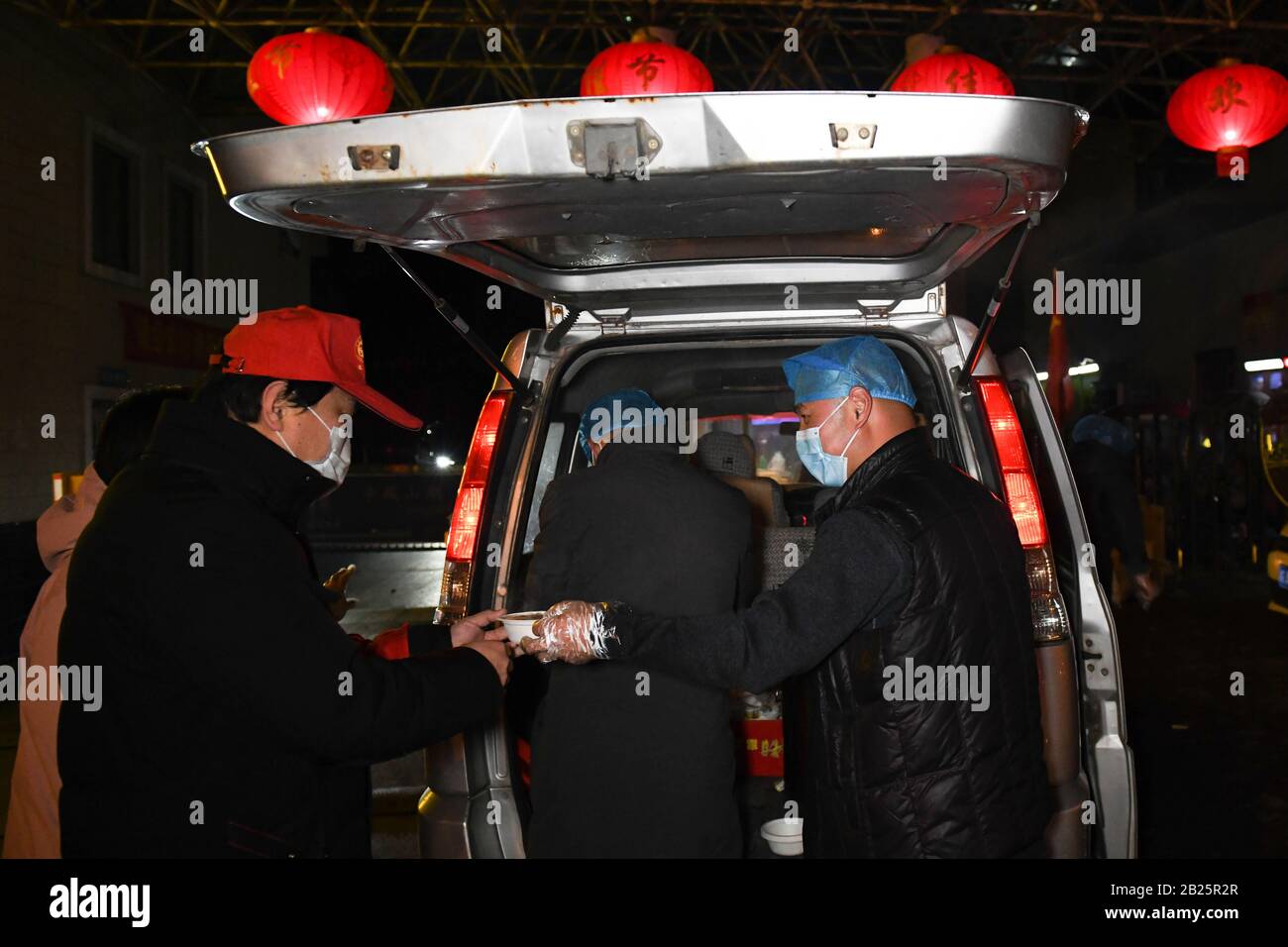 Anhui, Cina. 29th Feb, 2020. Zhang Shiyang (1st, R), nipote di Zhang Lanying, offre un pasto gratuito ad un operaio della comunità nel distretto di Shushan di Hefei, nella provincia di Anhui nella Cina orientale, 29 febbraio 2020. Zhang Lanying, un residente di 70 anni nel distretto Shushan di Hefei, offre pasti gratuiti per i lavoratori della comunità che soggiornano di notte per la prevenzione delle epidemie. Dal Febbraio: Credito Xinhua/Alamy Live News Foto Stock