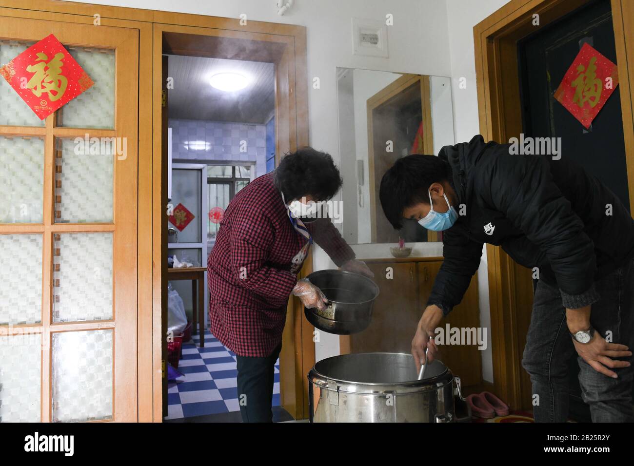 Anhui, Cina. 29th Feb, 2020. Zhang Lanying e suo figlio Xu Xiaojun preparano pasti gratuiti per i lavoratori della comunità nel distretto Shushan di Hefei, nella provincia dell'Anhui nella Cina orientale, 28 febbraio 2020. Zhang Lanying, un residente di 70 anni nel distretto Shushan di Hefei, offre pasti gratuiti per i lavoratori della comunità che soggiornano di notte per la prevenzione delle epidemie. Dal Febbraio: Credito Xinhua/Alamy Live News Foto Stock