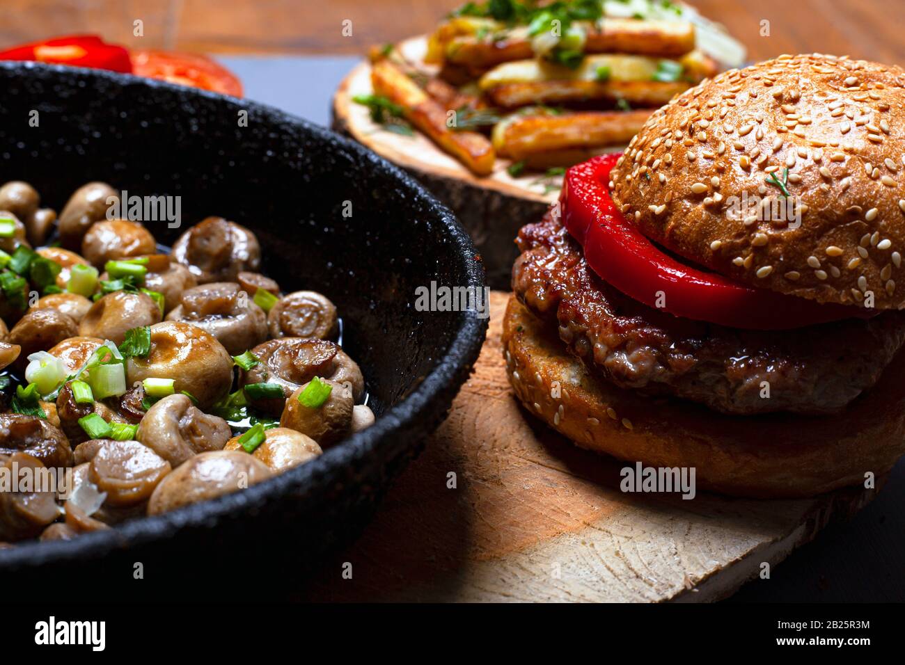 concetto di cibo grasso. cibo non sano hamburger e funghi fritti. Foto Stock