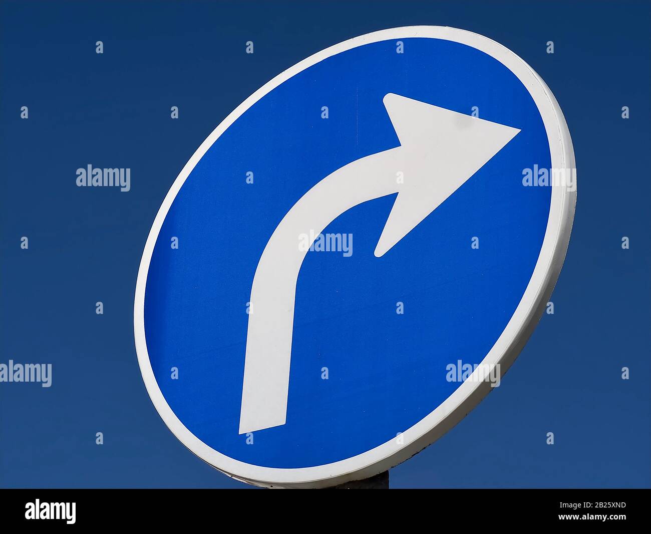 Strada girare a destra con una freccia bianca Foto Stock