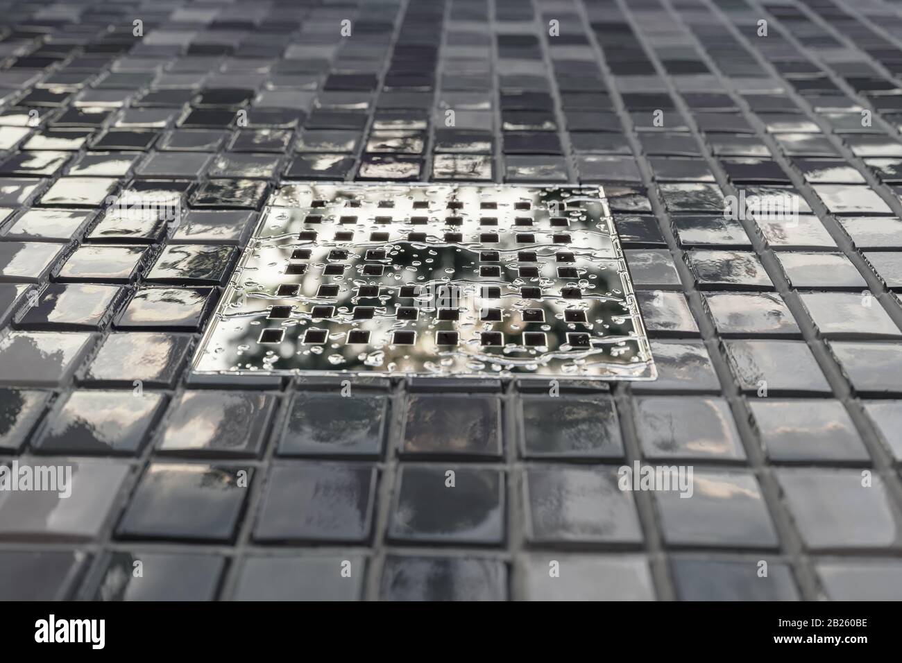 3d rendering di grondaia in metallo cromato con gocce d'acqua e piastrelle  mosaico pavimento in luce serale Foto stock - Alamy