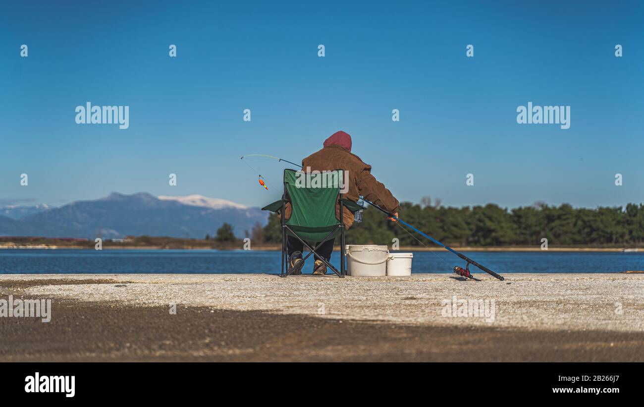 povero pescatore in azione con canna da pesca Foto Stock