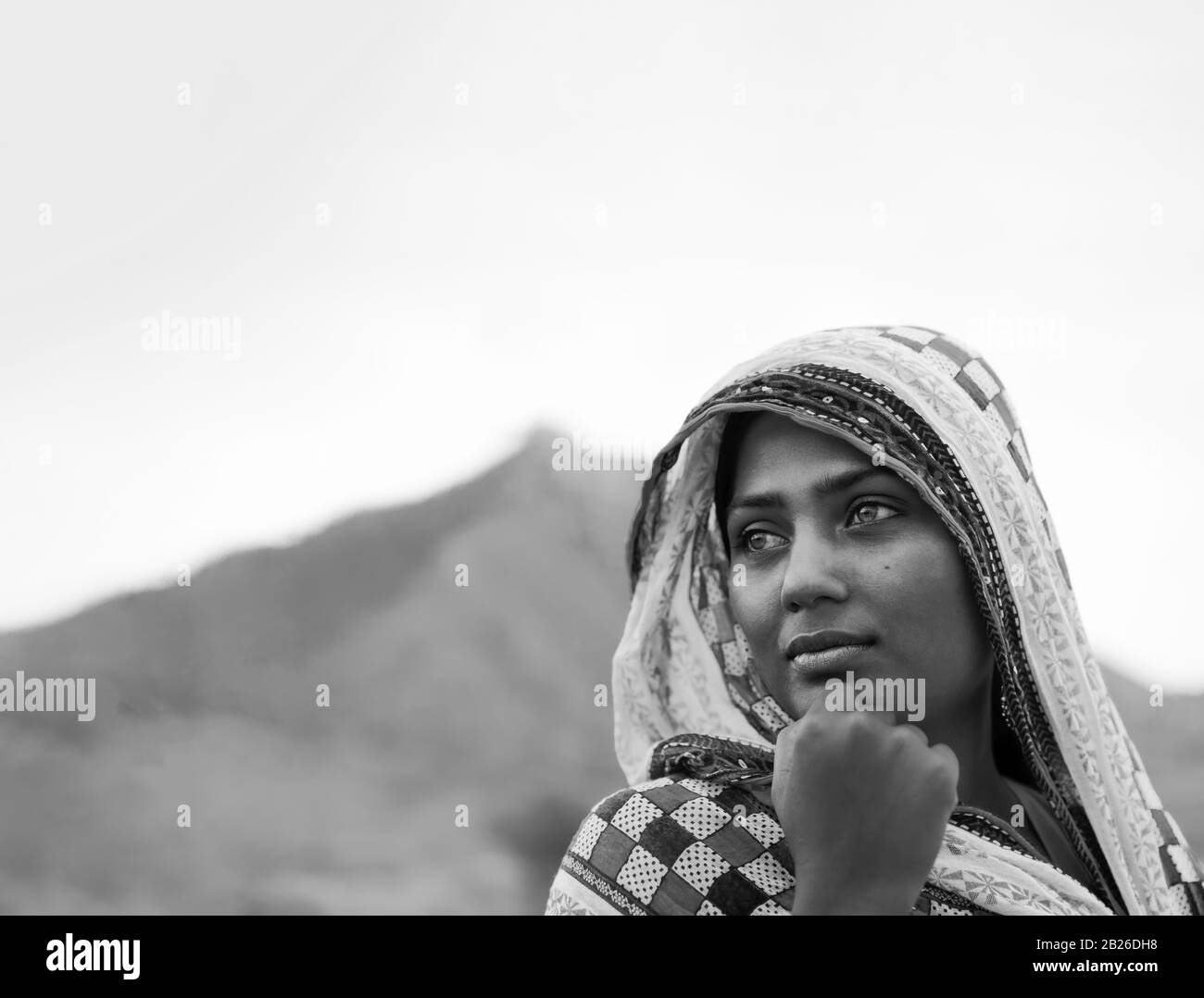 Giovane bella donna zingara in abiti tradizionali e profondo nel pensiero nel deserto Thar all'alba vicino Pushkar, Rajasthan, India. Foto Stock