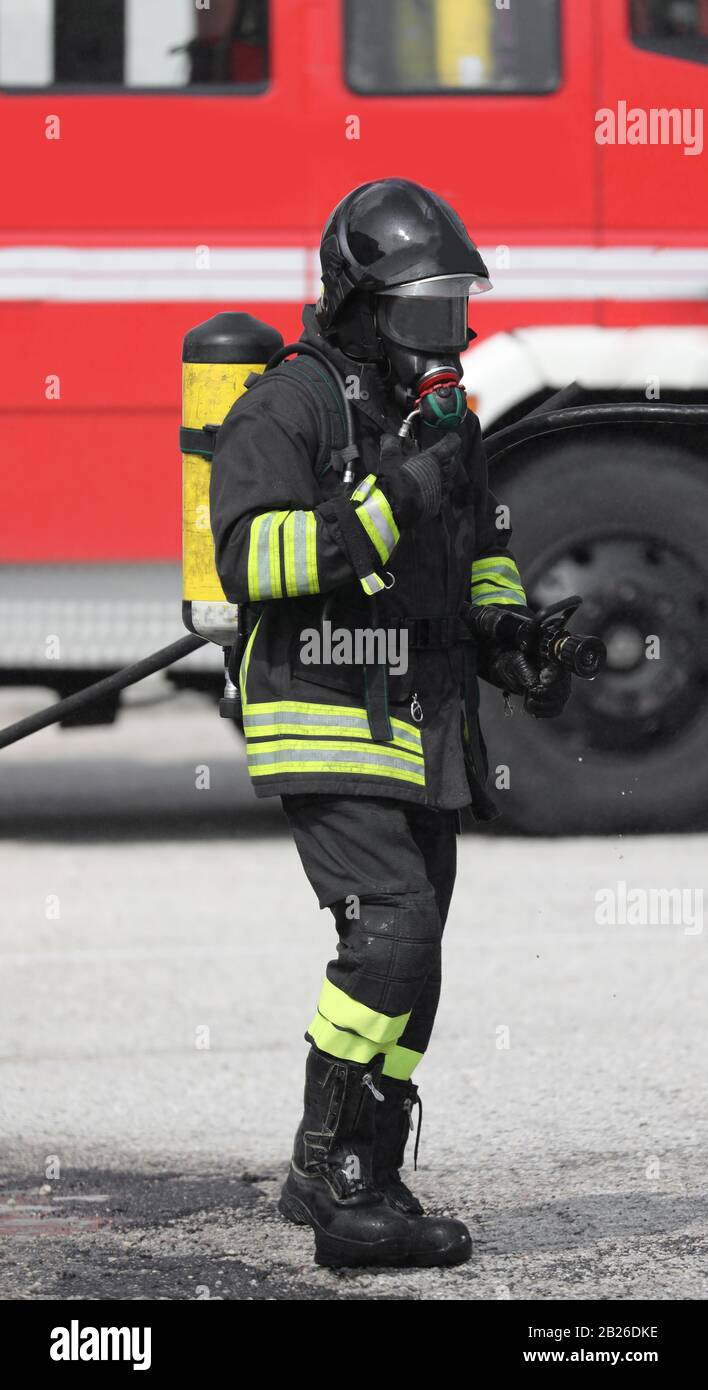 Pompiere con bombola di ossigeno e grandi stivali neri durante un'emergenza  Foto stock - Alamy