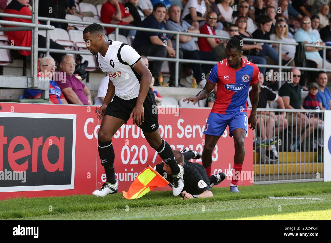 Alexander McQueen di Dagenham e Ibou Touray di Salford collide con l'assistente dell'arbitro durante Dagenham & Redbridge vs Salford City, Vanarama Na Foto Stock