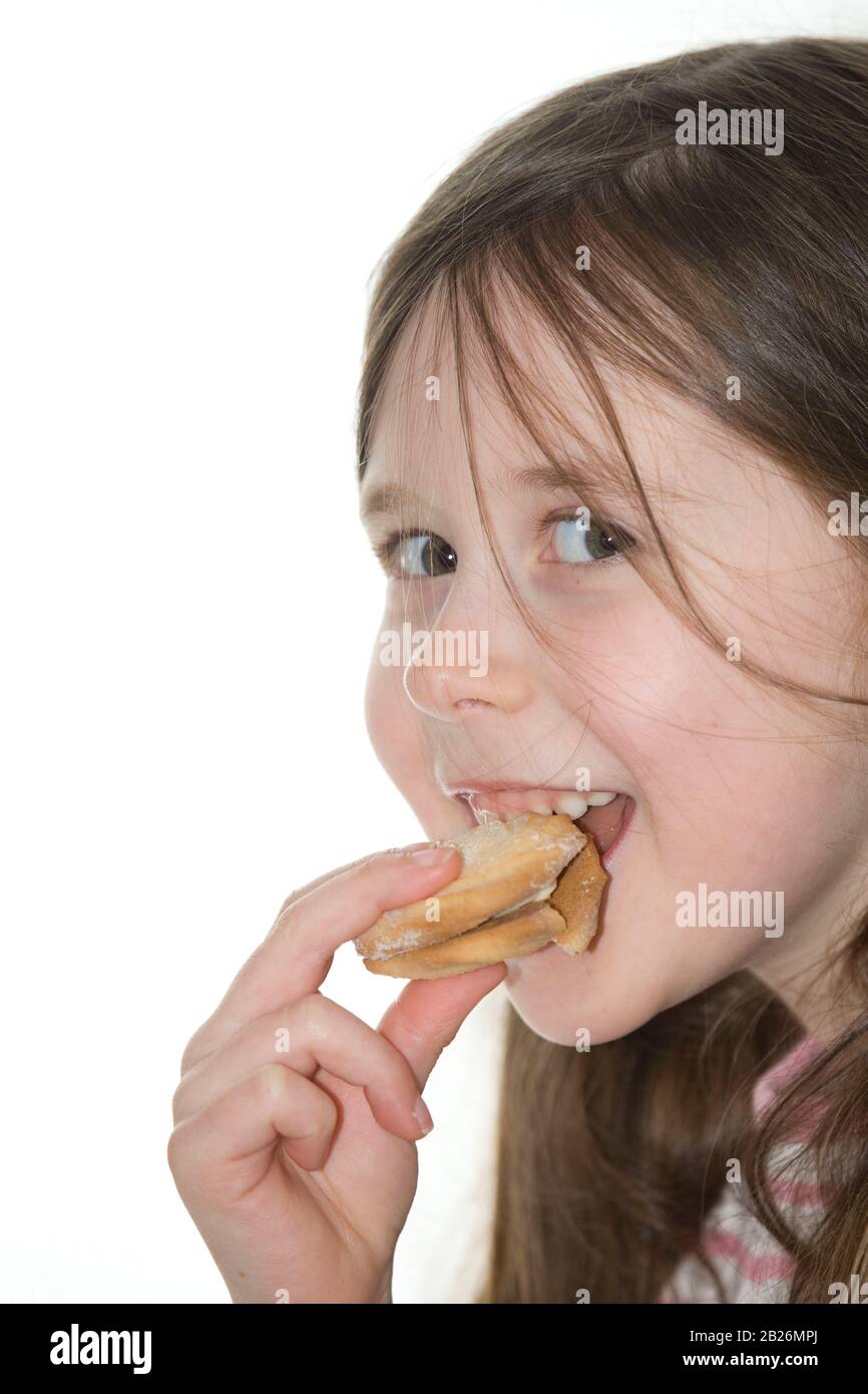 giovane ragazza che mangia un biscotto di vortice viennese Foto Stock