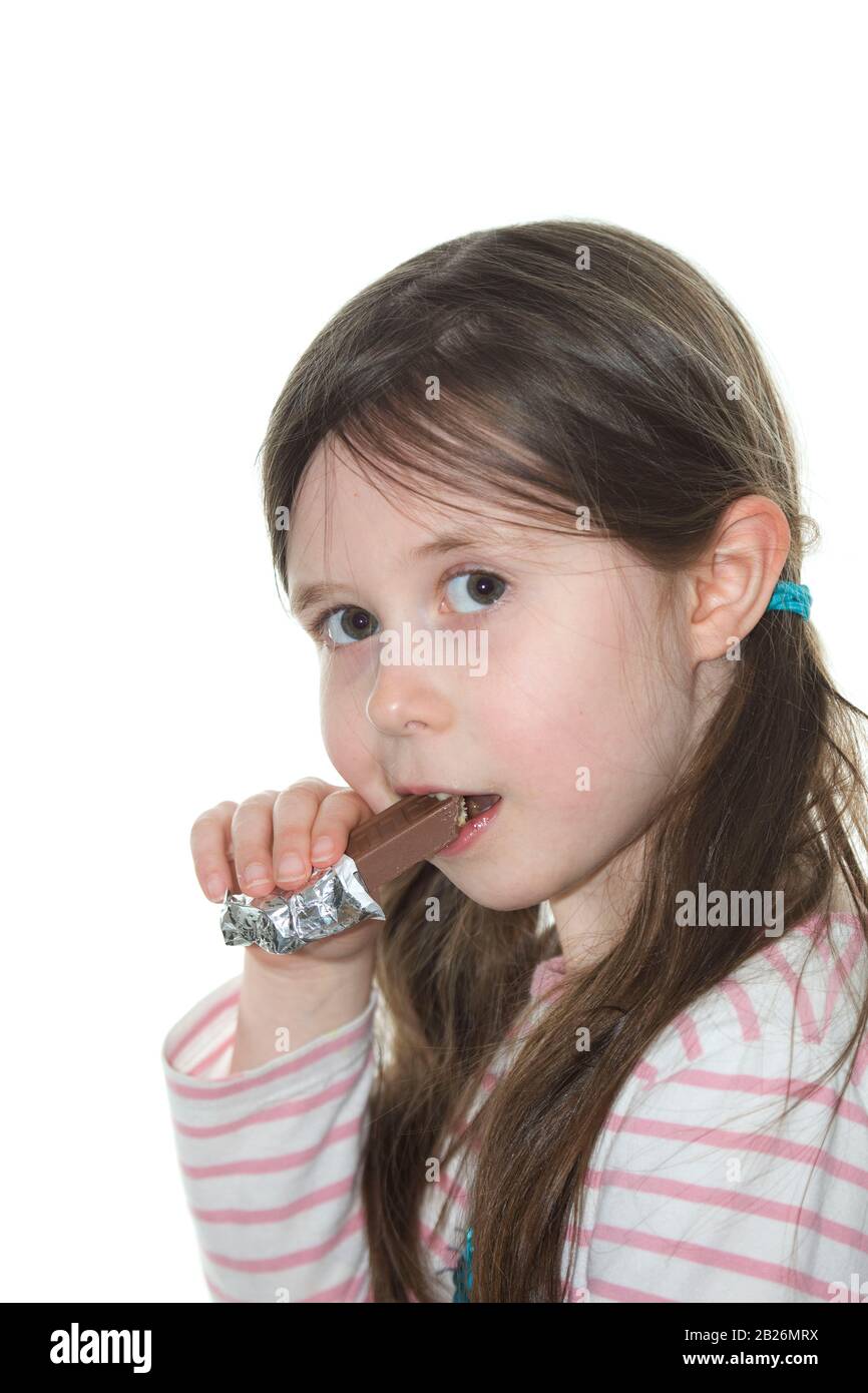 Giovane ragazza che mangia un biscotto al cioccolato Foto Stock
