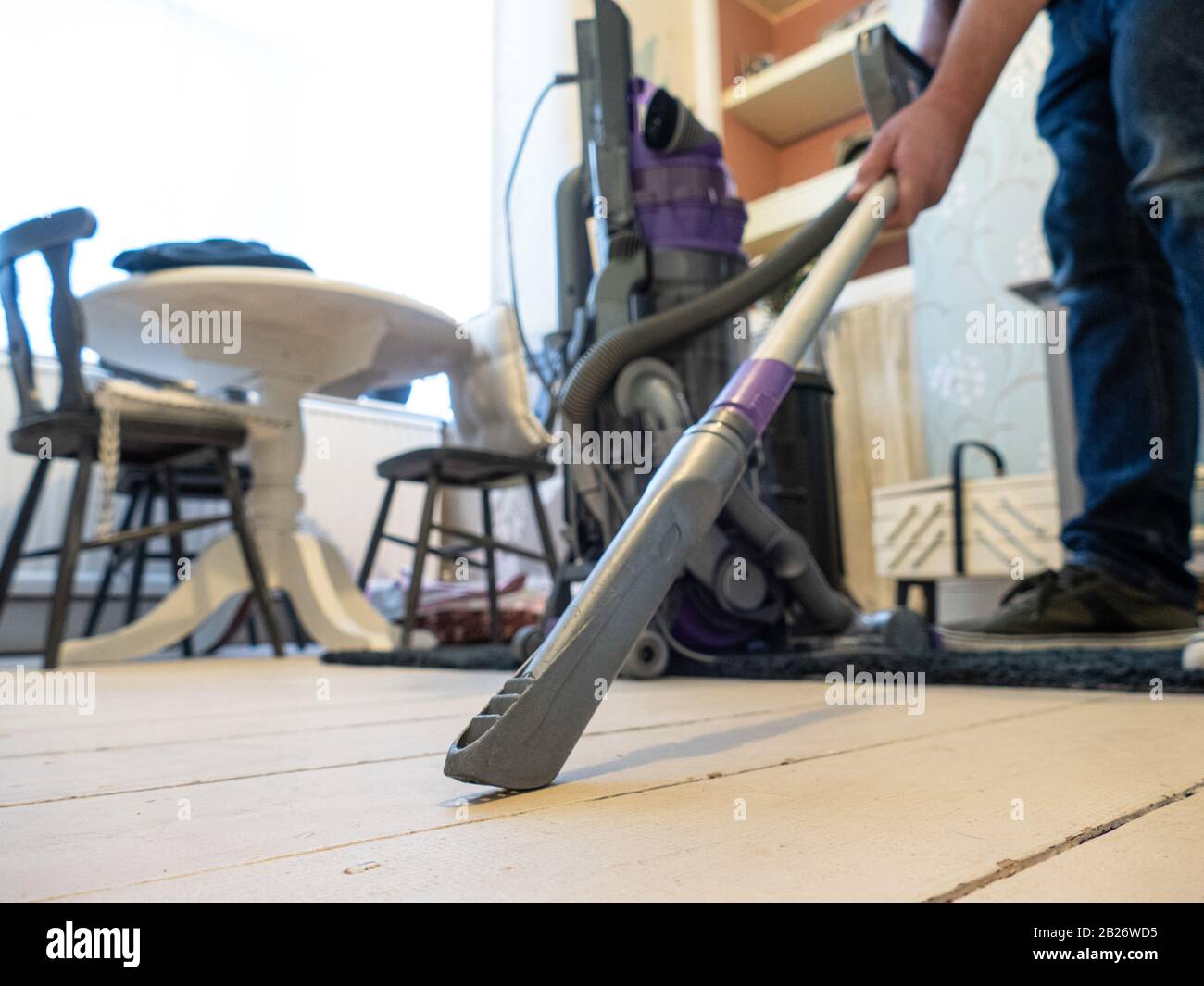 Moderno uomo che vacuuming pavimenti Foto Stock