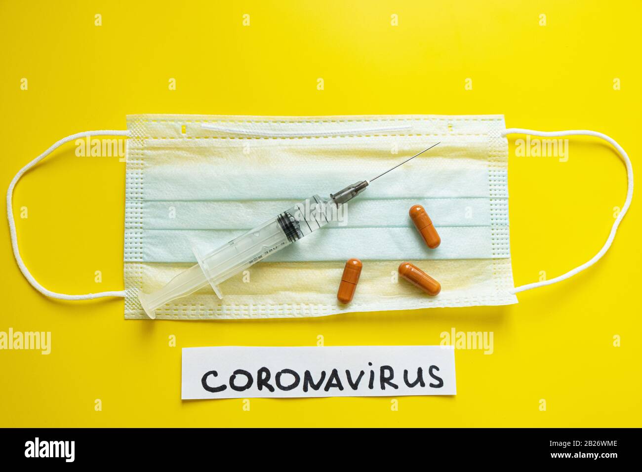 Coronavirus CoVid 19 trattamento di protezione del concetto di diffusione. Maschera medica, compresse a siringa su sfondo giallo brillante Foto Stock