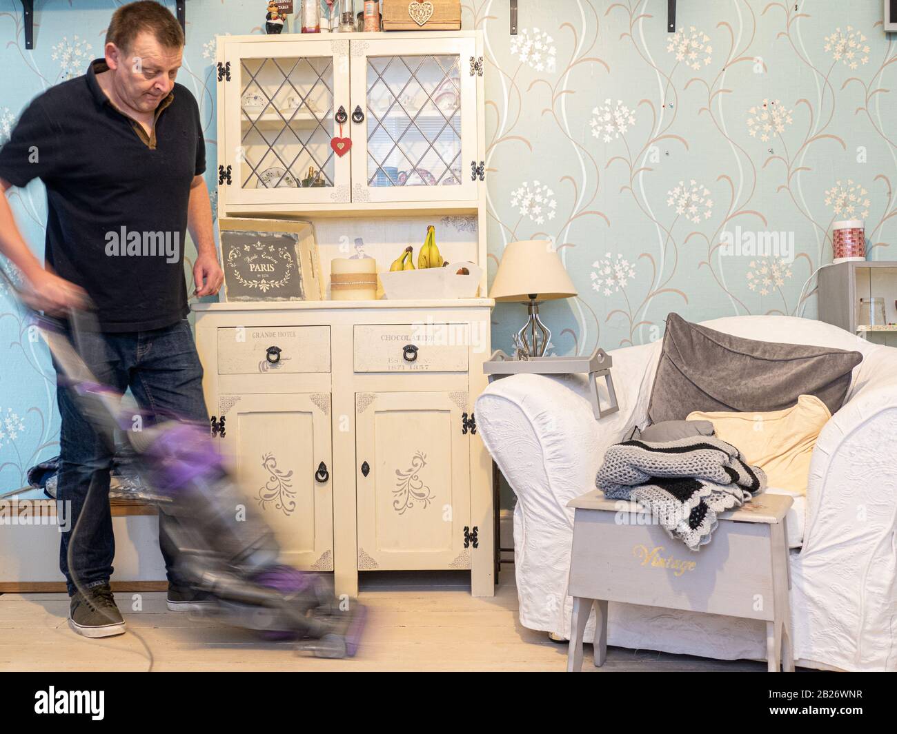 Moderno uomo che vacuuming pavimenti Foto Stock