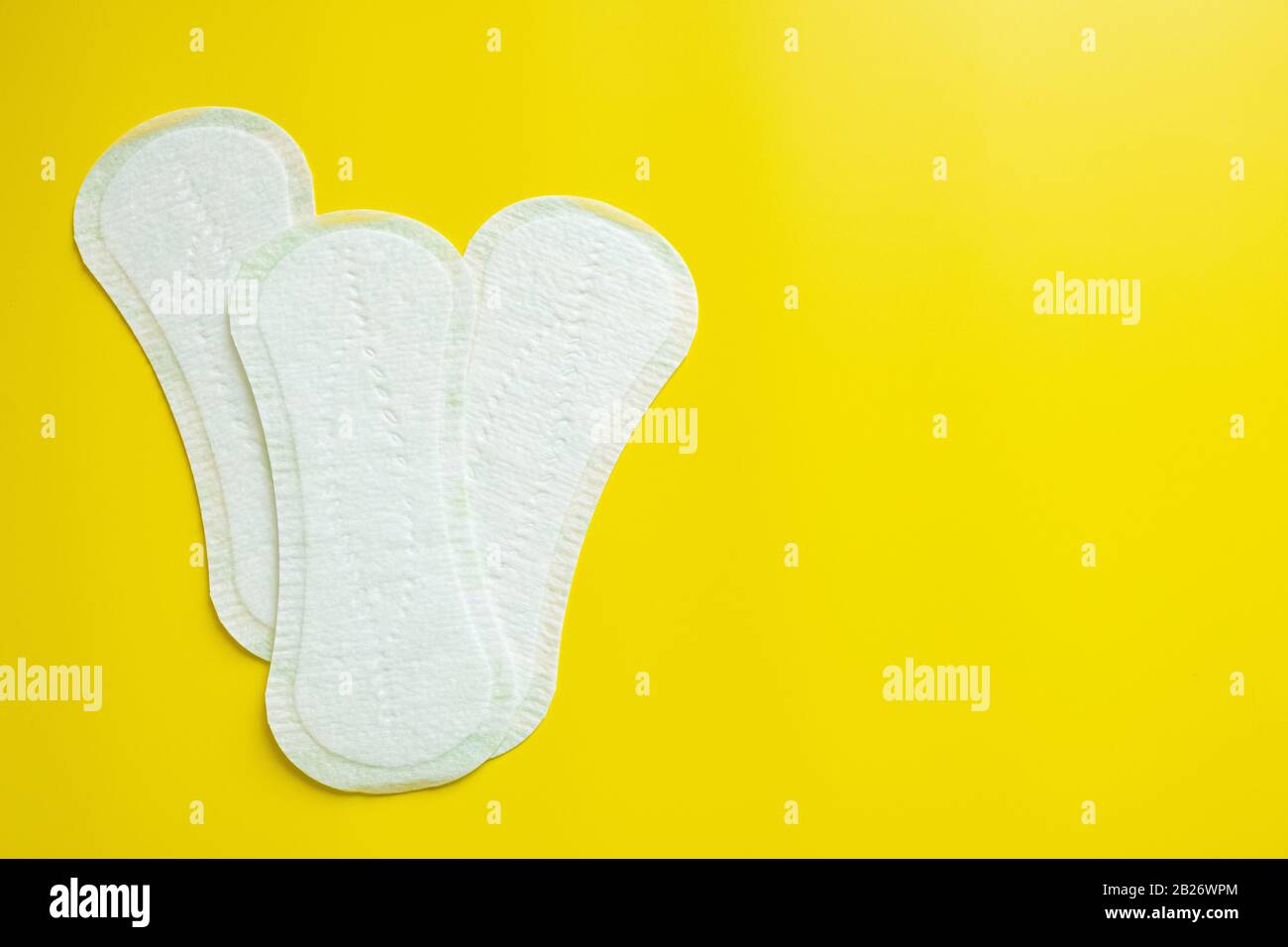 assorbente igienico quotidiano su uno sfondo giallo brillante primo piano dello spazio di copia Foto Stock