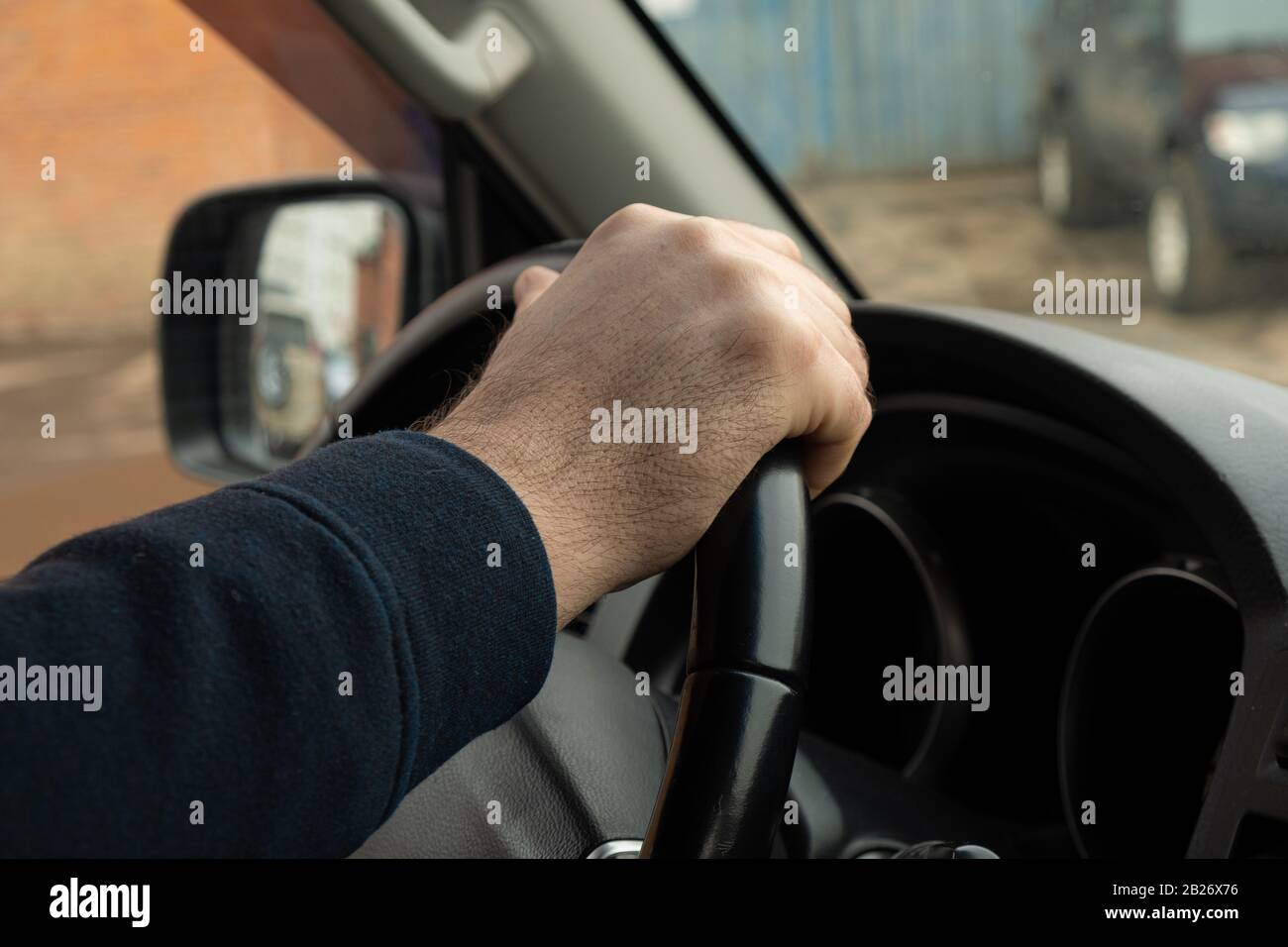 Mano dell'uomo che tiene il volante di un tassista di primo piano della macchina funzionante Foto Stock