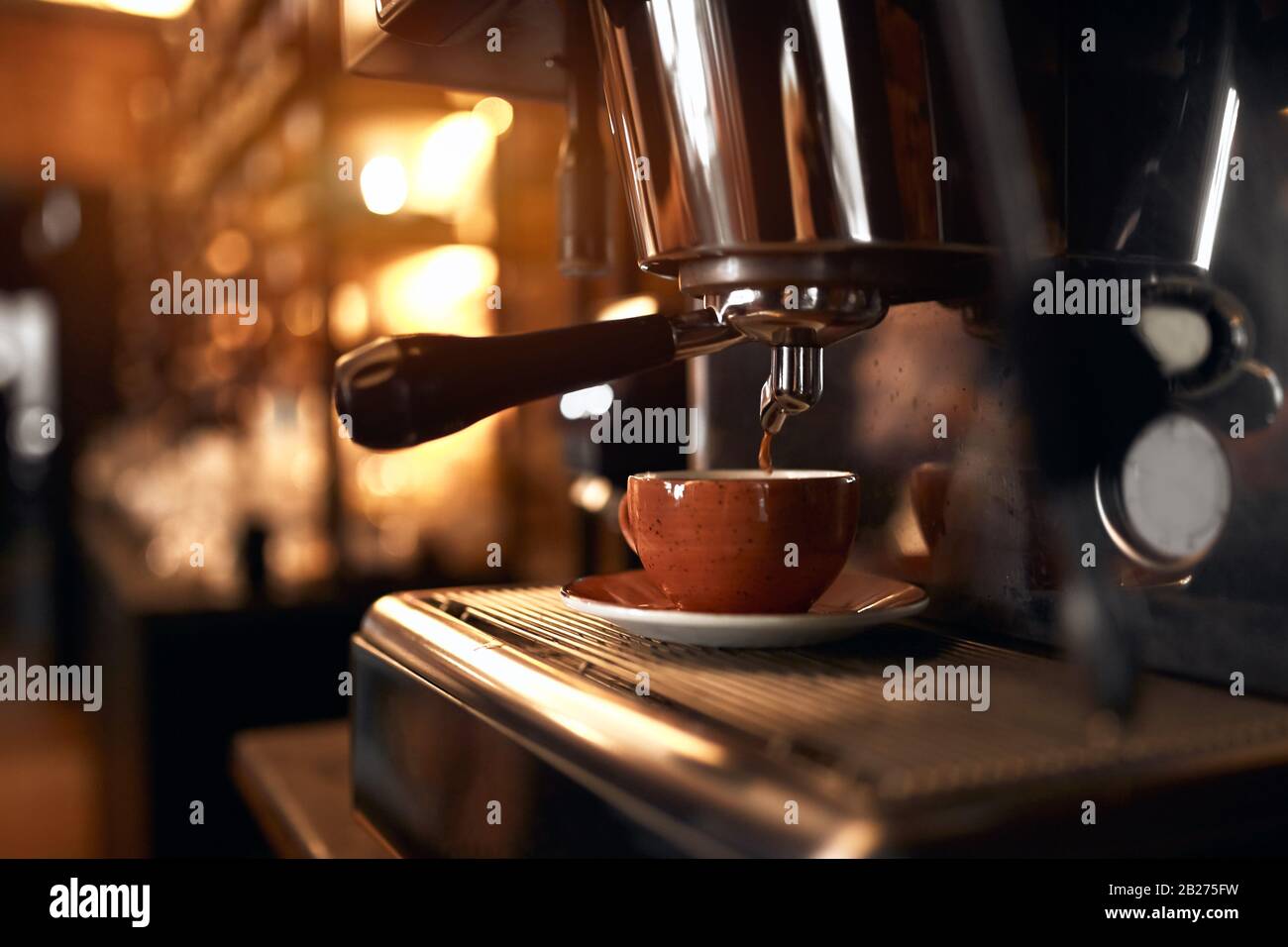 Caffè in balc fresco e forte preparato nella macchina da caffè. Espresso in una piccola tazza marrone Foto Stock
