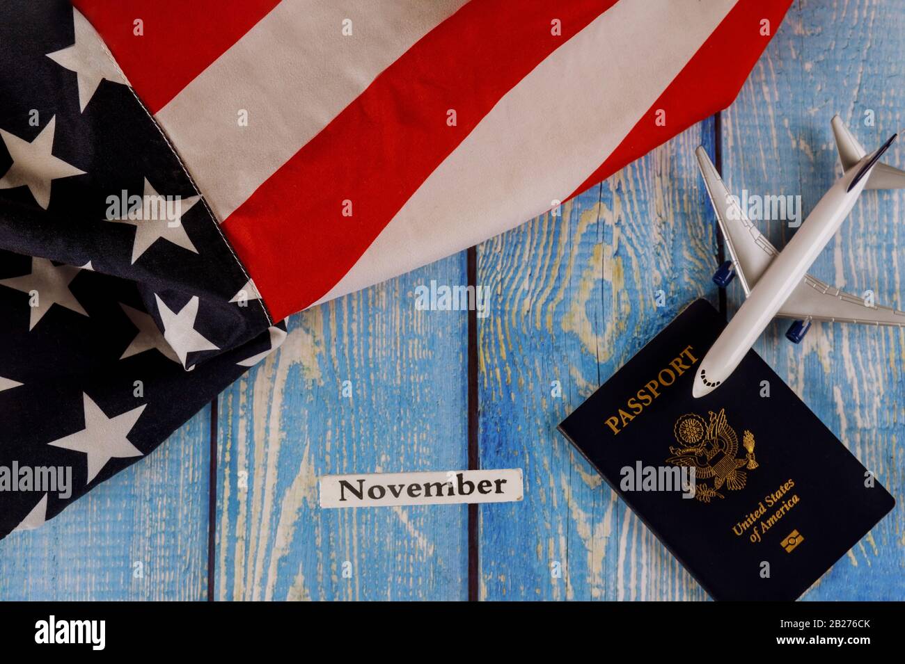 Mese di novembre dell'anno civile, turismo di viaggio, emigrazione la bandiera nazionale americana degli Stati Uniti con passaporto degli Stati Uniti e aereo modello del passeggero Foto Stock
