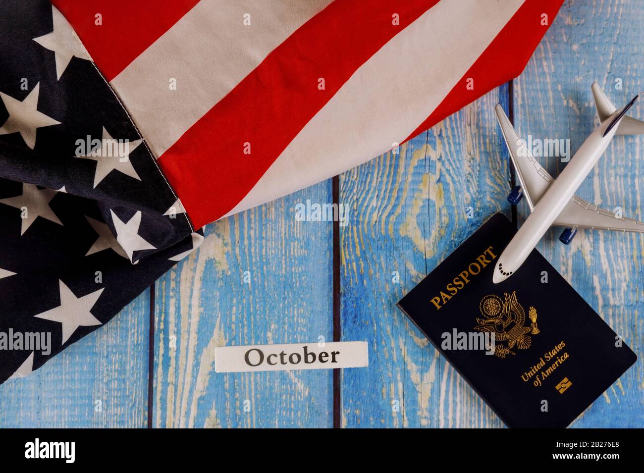 Mese di ottobre dell'anno civile, turismo di viaggio, emigrazione la bandiera nazionale americana degli Stati Uniti con passaporto degli Stati Uniti e aereo modello del passeggero Foto Stock