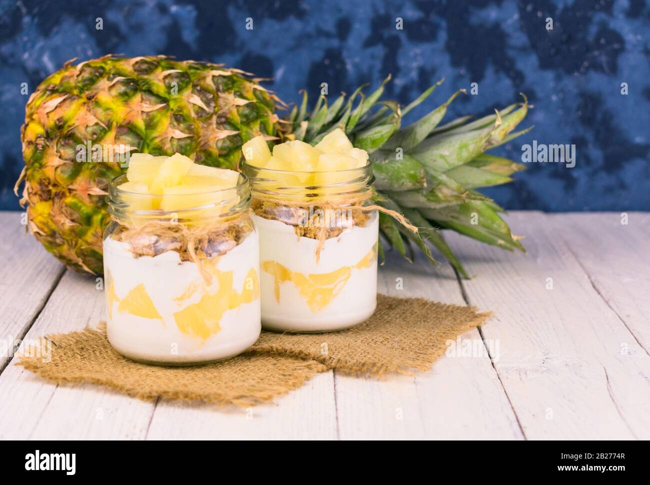 Due vasetti di yogurt all'ananas fatto in casa. Un concetto di dessert leggeri e sani. Foto Stock