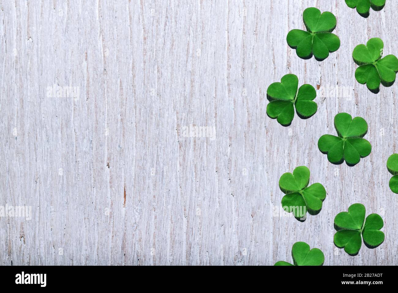 Modello di foglie di shamrock su sfondo bianco shabby legno con spazio libero copia. Giornata di San Patrizio, focus selettivo. Foto Stock