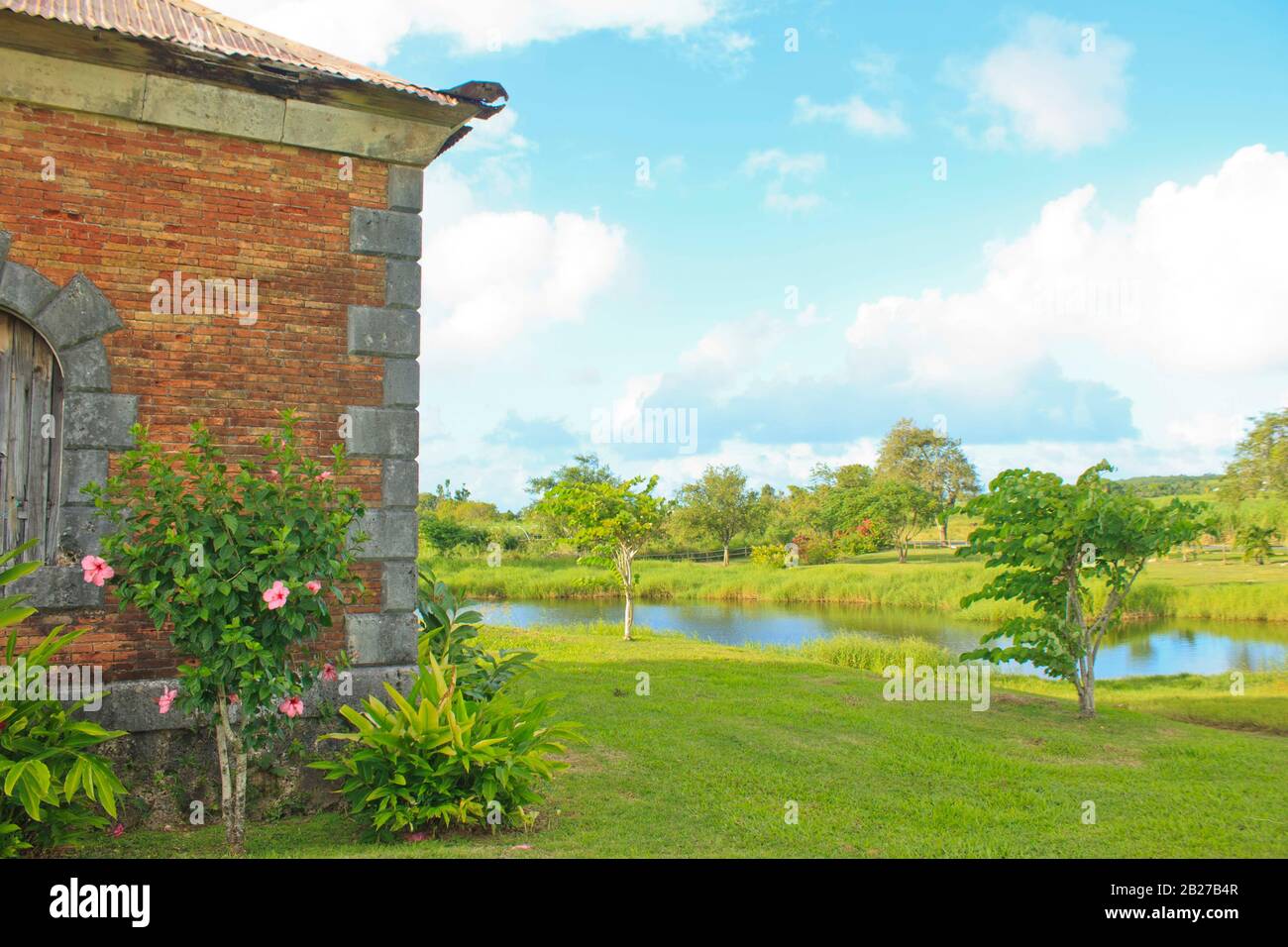 Antico edificio coloniale in mattoni situato su acri di verde vicino a uno stagno di Habitation Roussel Trianon a Marie Galante de Guadalupa Foto Stock