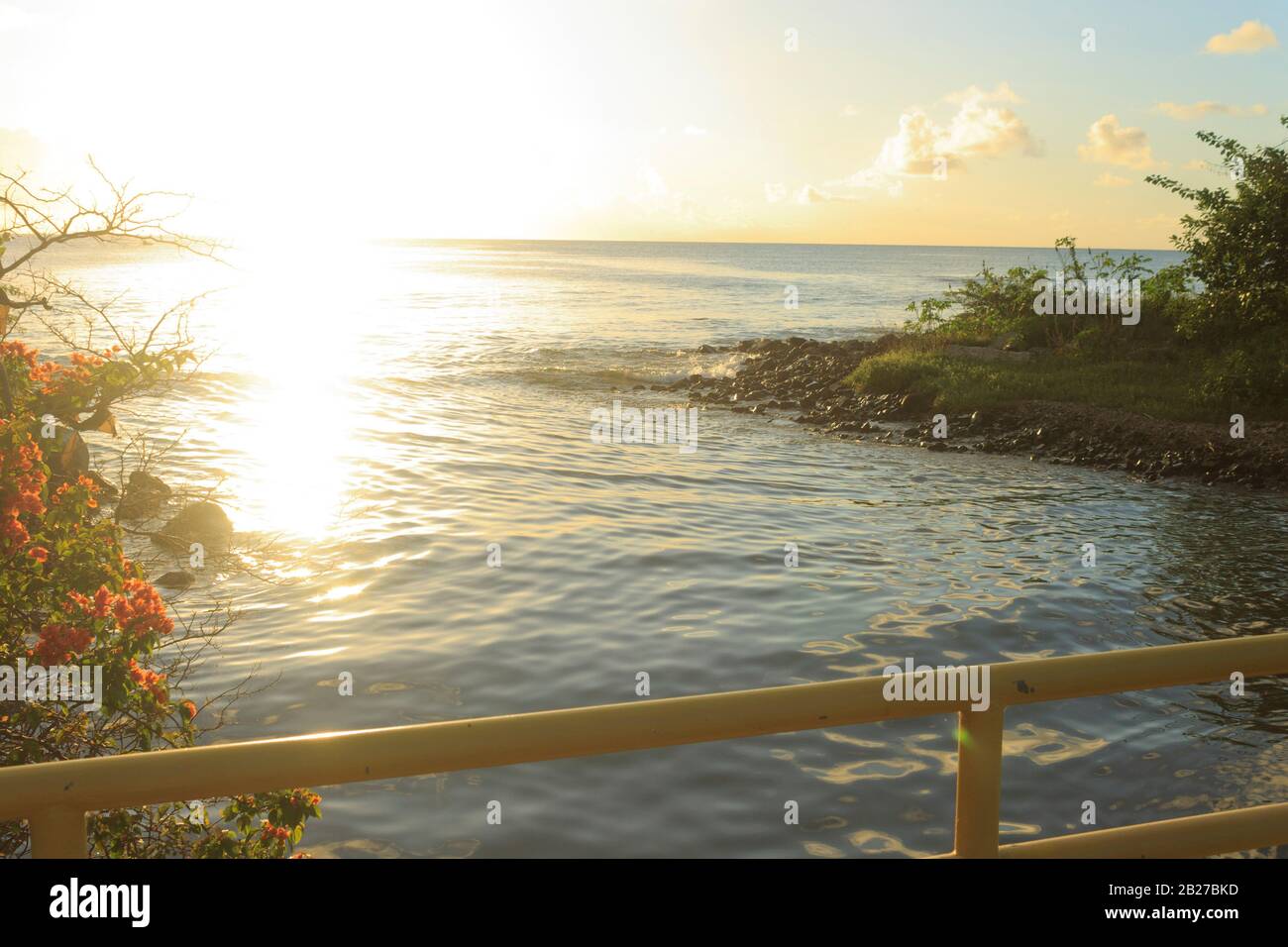 Suggestiva vista da un ponte, di acqua di mare che precipitano in un estuario durante un tramonto più affascinante a Gros-Islet, Santa Lucia Foto Stock