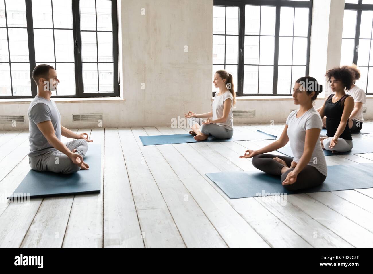 Persone sedute in posizione lotus durante la pratica meditazione consapevolezza Foto Stock