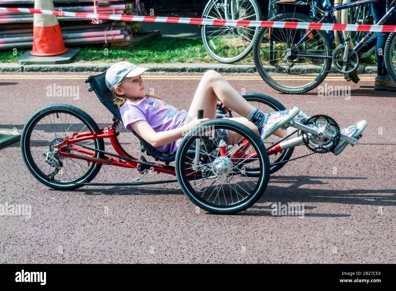 Ragazza di nove anni su un triciclo reclinato in un evento ciclistico, Londra, Regno Unito Foto Stock