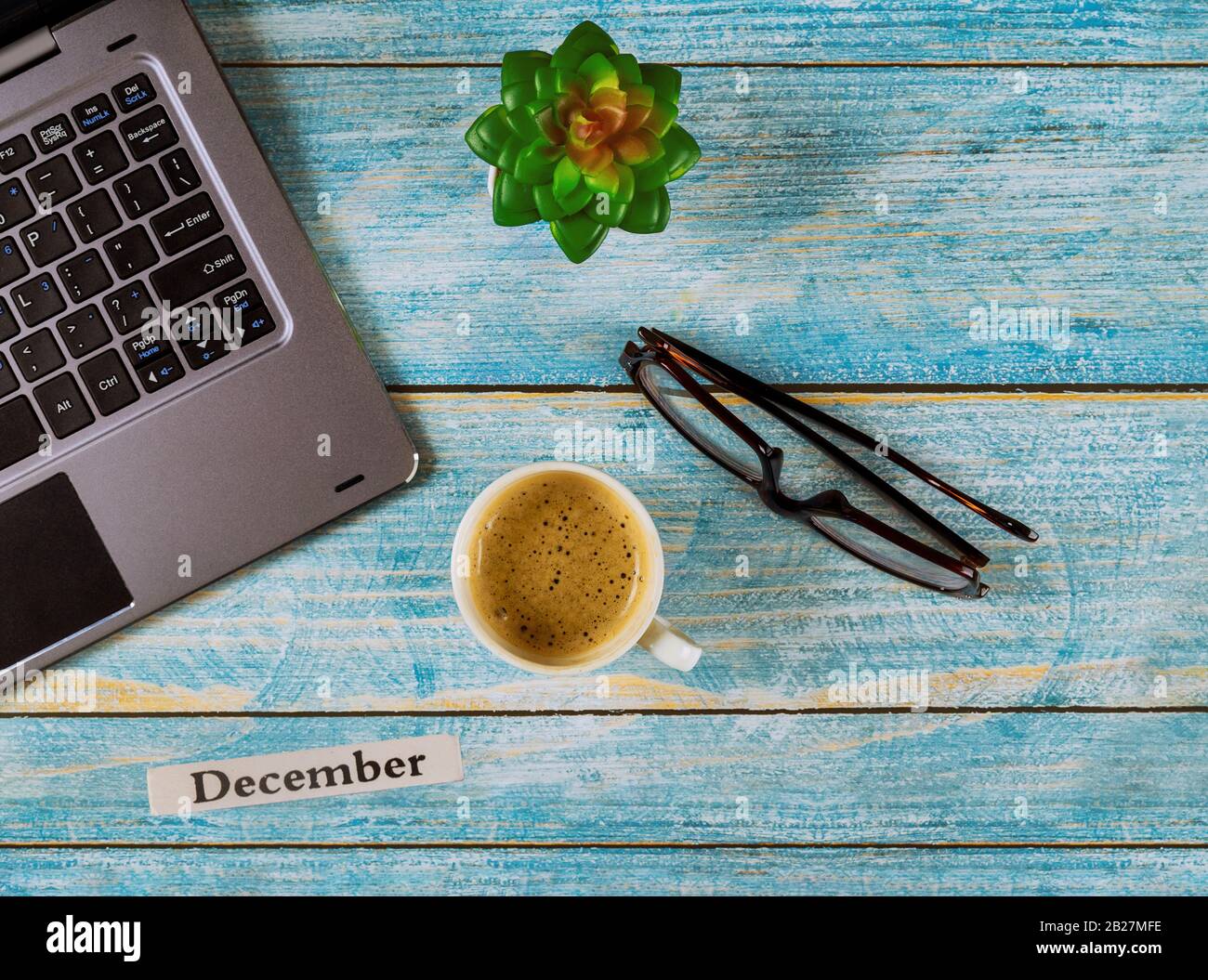 Spazio di lavoro con mese di dicembre dell'anno solare, tavolo da ufficio con computer e tazza da caffè, vista degli occhiali Foto Stock