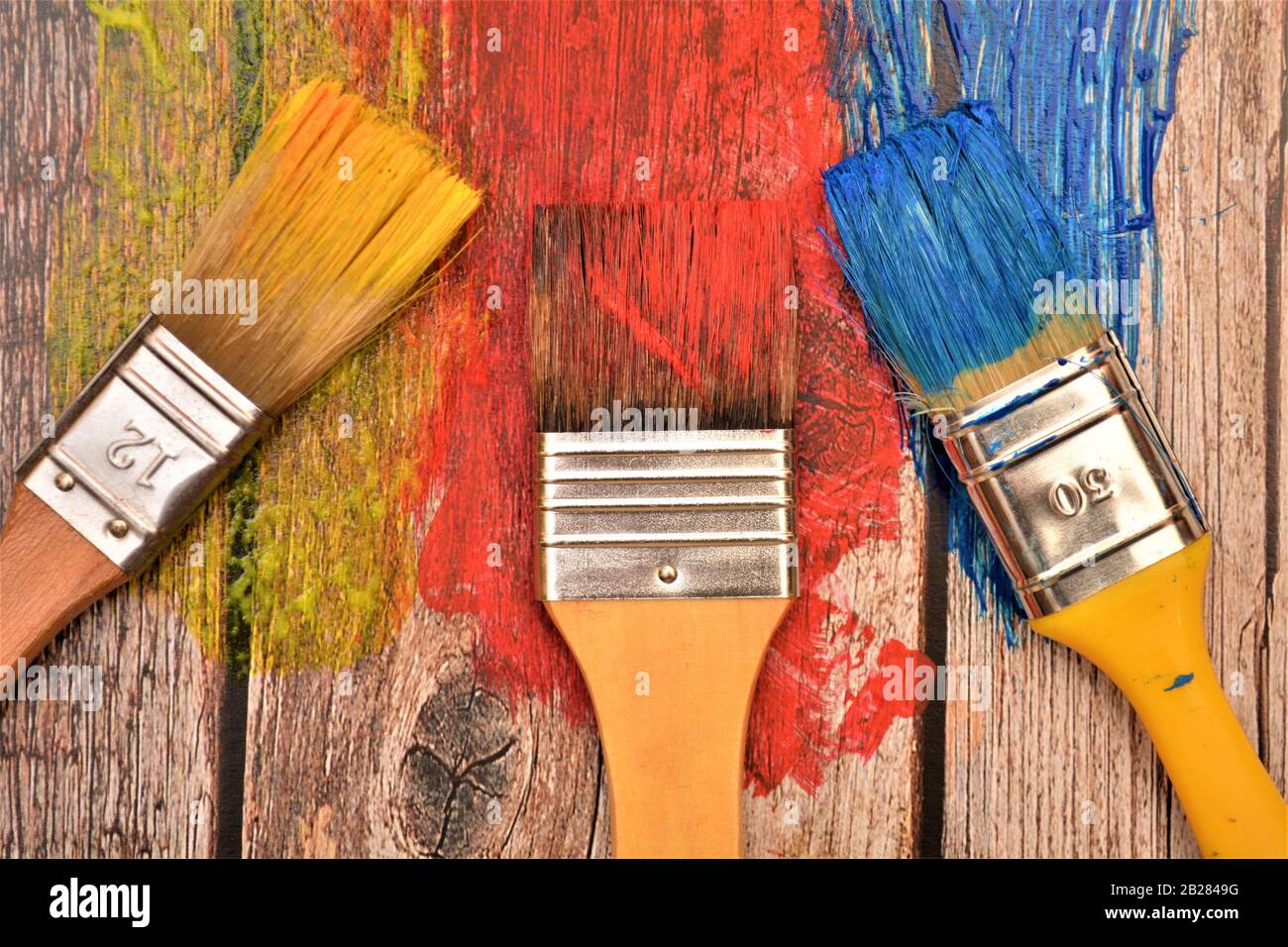 pennello per pittura colori rosso blu giallo su sfondo di legno Foto stock  - Alamy