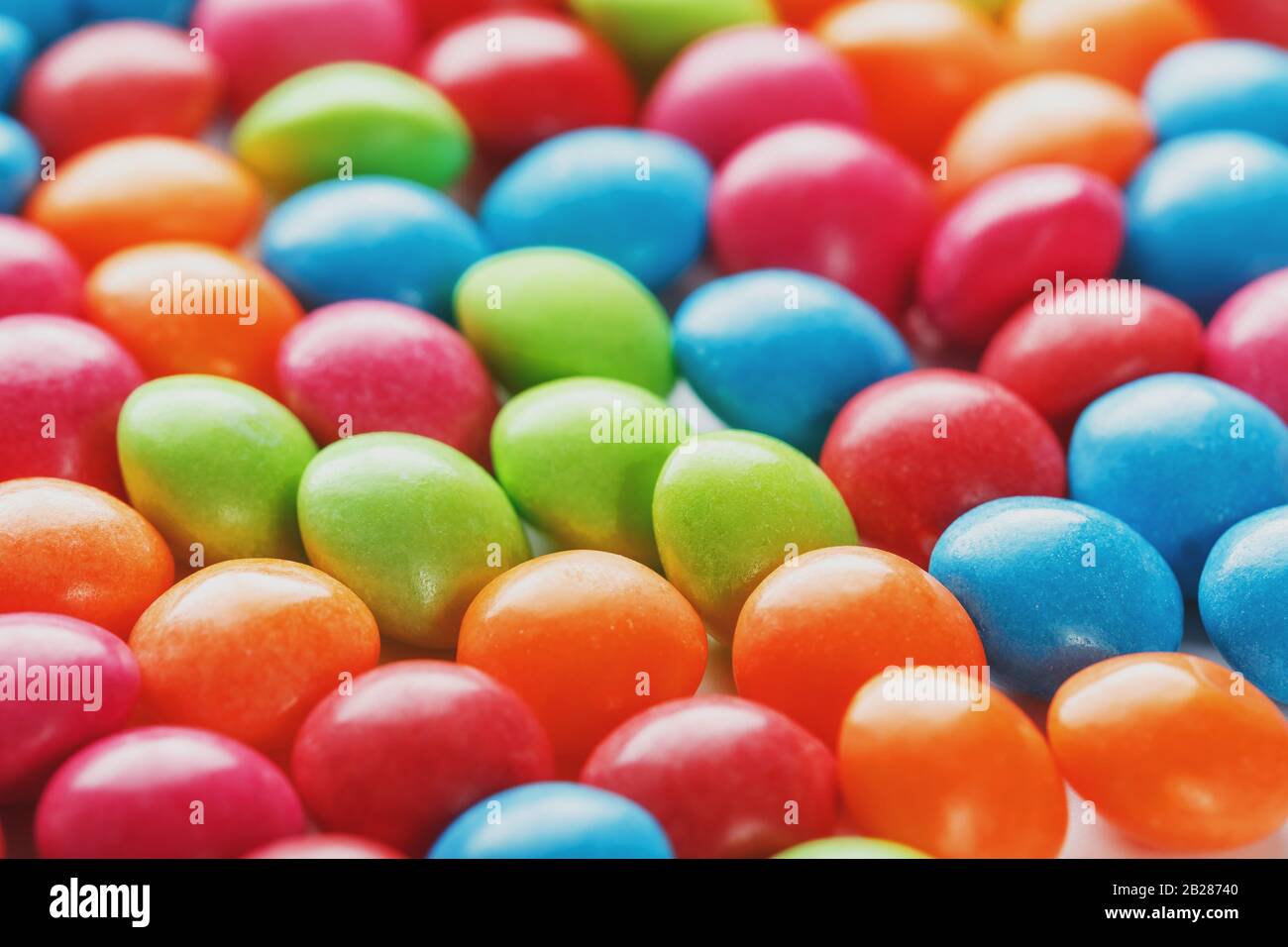 Colori arcobaleno di caramelle multicolore primo piano, texture e ripetizione di draghi Foto Stock