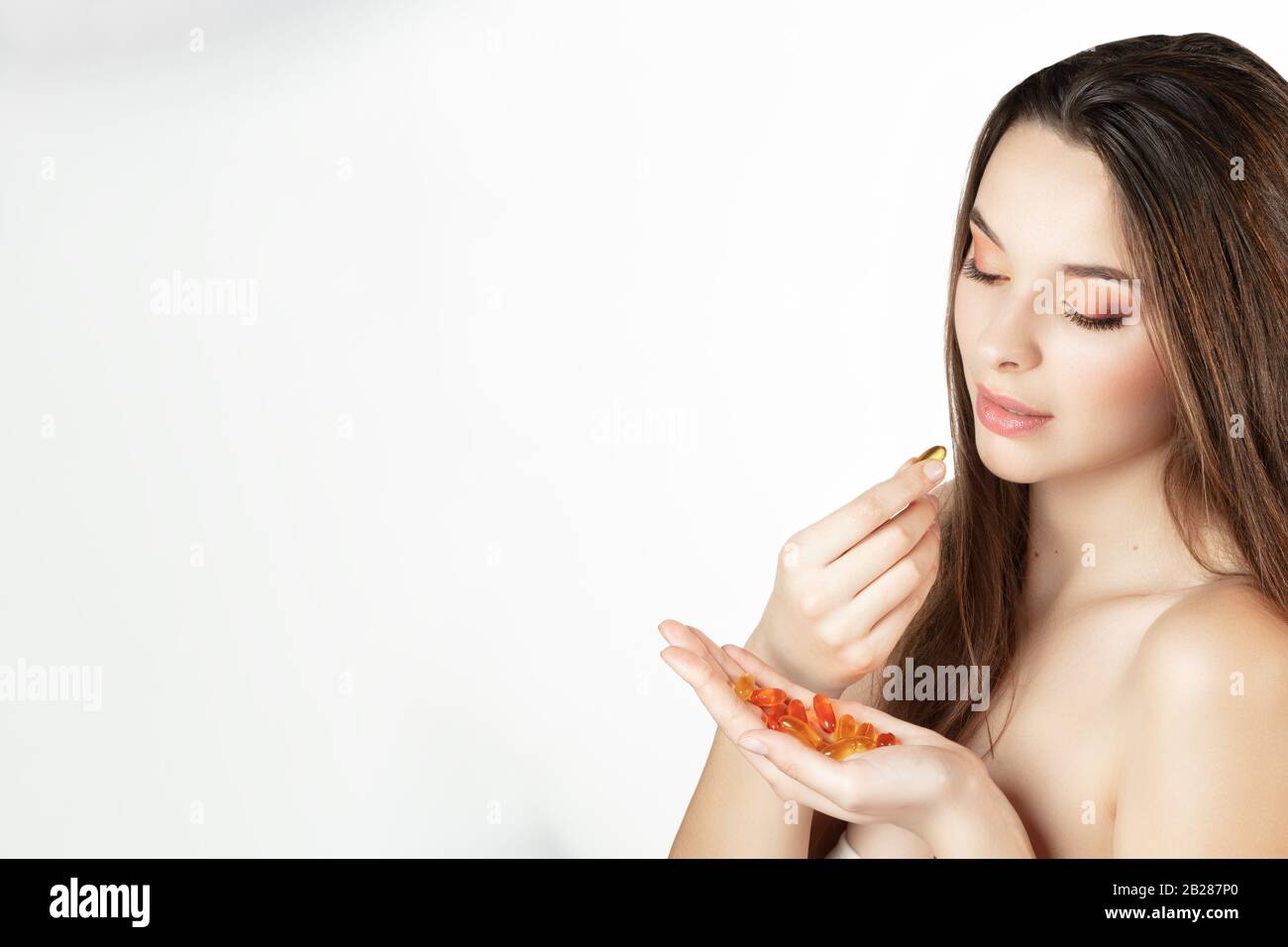 Ritratto di una giovane donna si prepara a prendere una capsula di elementi in tracce Foto Stock