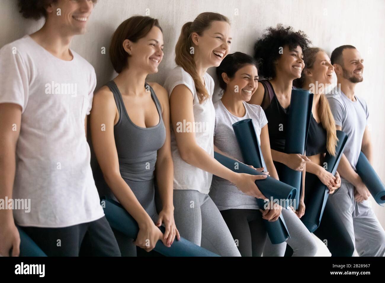 Persone sportive che indossano tappeti per lo yoga con abbigliamento sportivo pronti per l'allenamento Foto Stock
