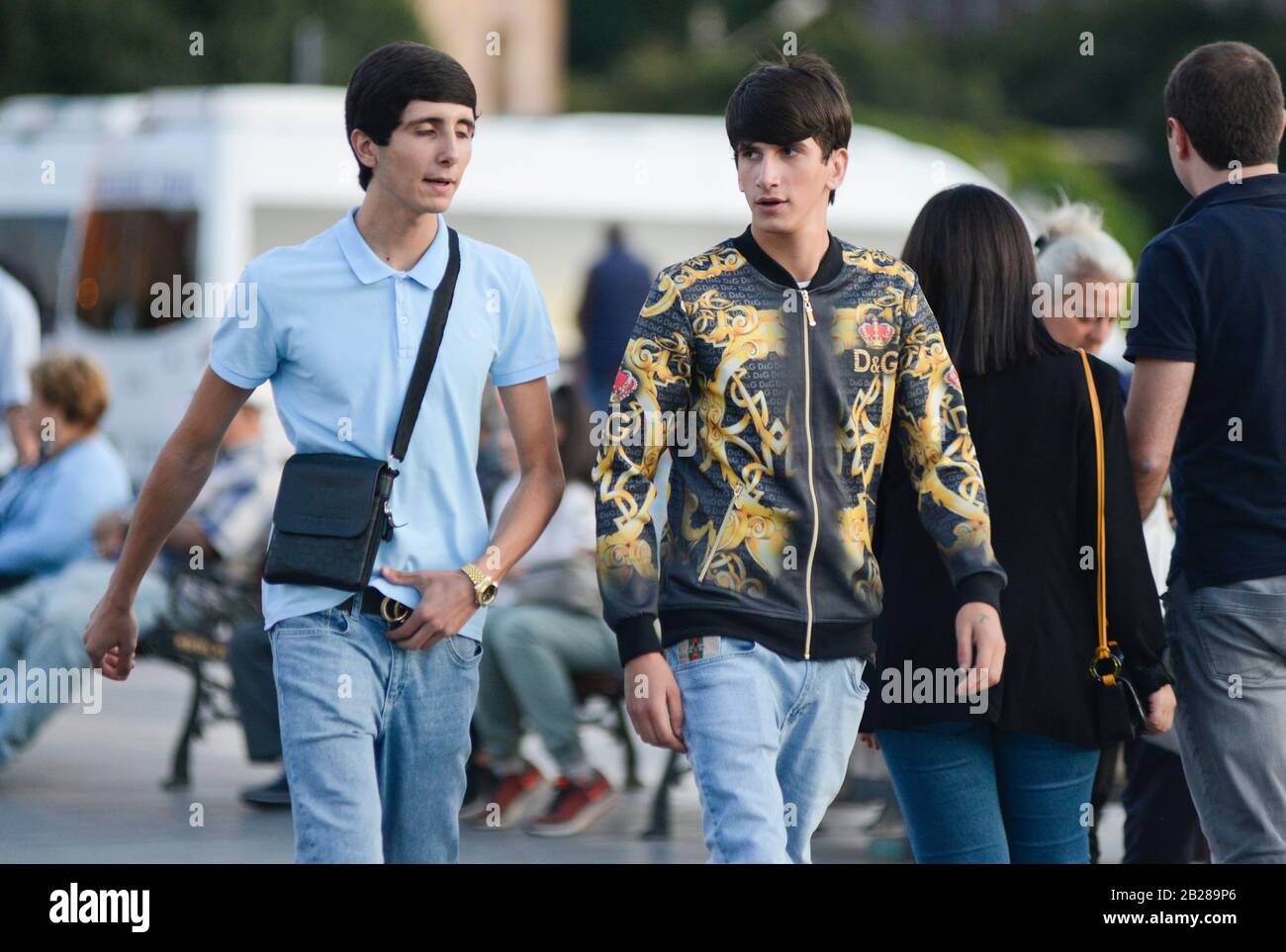 Giovani amici che camminano in Piazza della Repubblica, Yerevan, Armenia Foto Stock