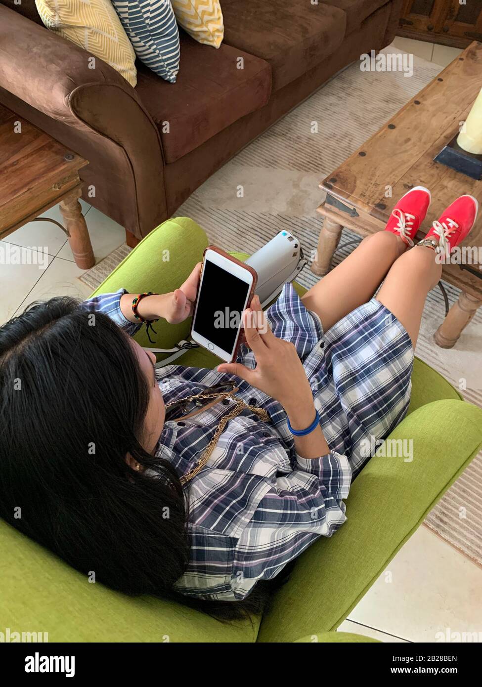 Giovane donna latina con cellulare a casa sua, Panama, America Centrale Foto Stock