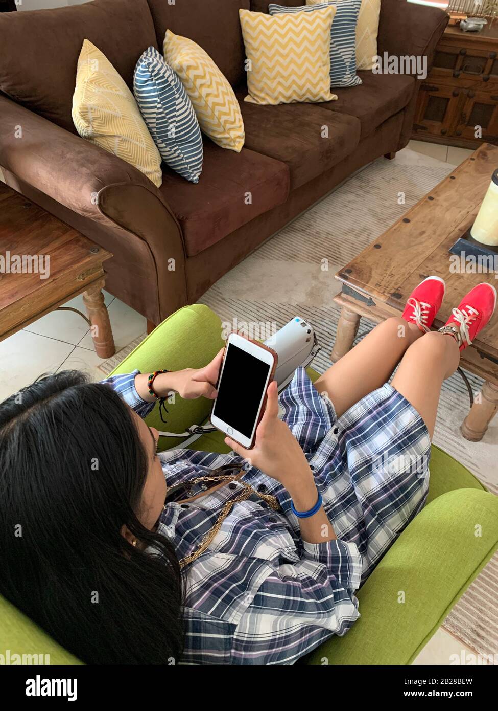 Giovane donna latina con cellulare a casa sua, Panama, America Centrale Foto Stock