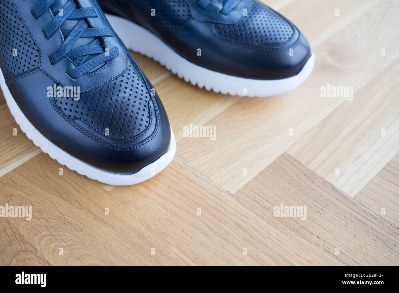 sneaker trendy in pelle blu lusso con allagamento in legno Foto Stock
