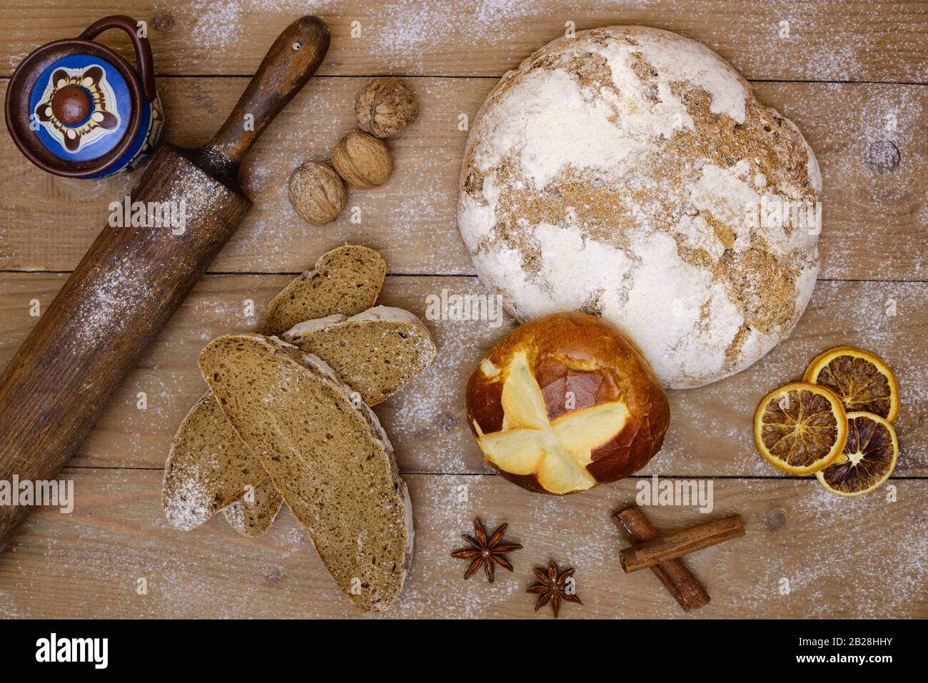 Pane fresco e fette di pane su tavole di legno con pane a spina di laminazione in stile retrò, noci e spezie. Vista dall'alto, brochure e banner per groc Foto Stock