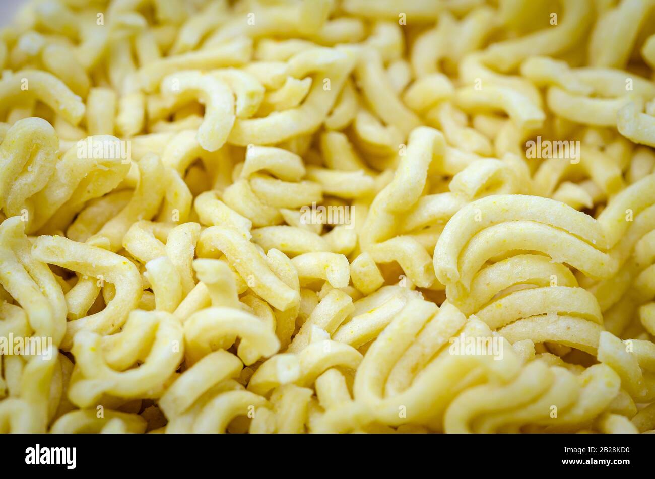 Closeup di noodles istantanei prelevati dal pacchetto, pronti per essere cotti. Sfondo. Foto Stock