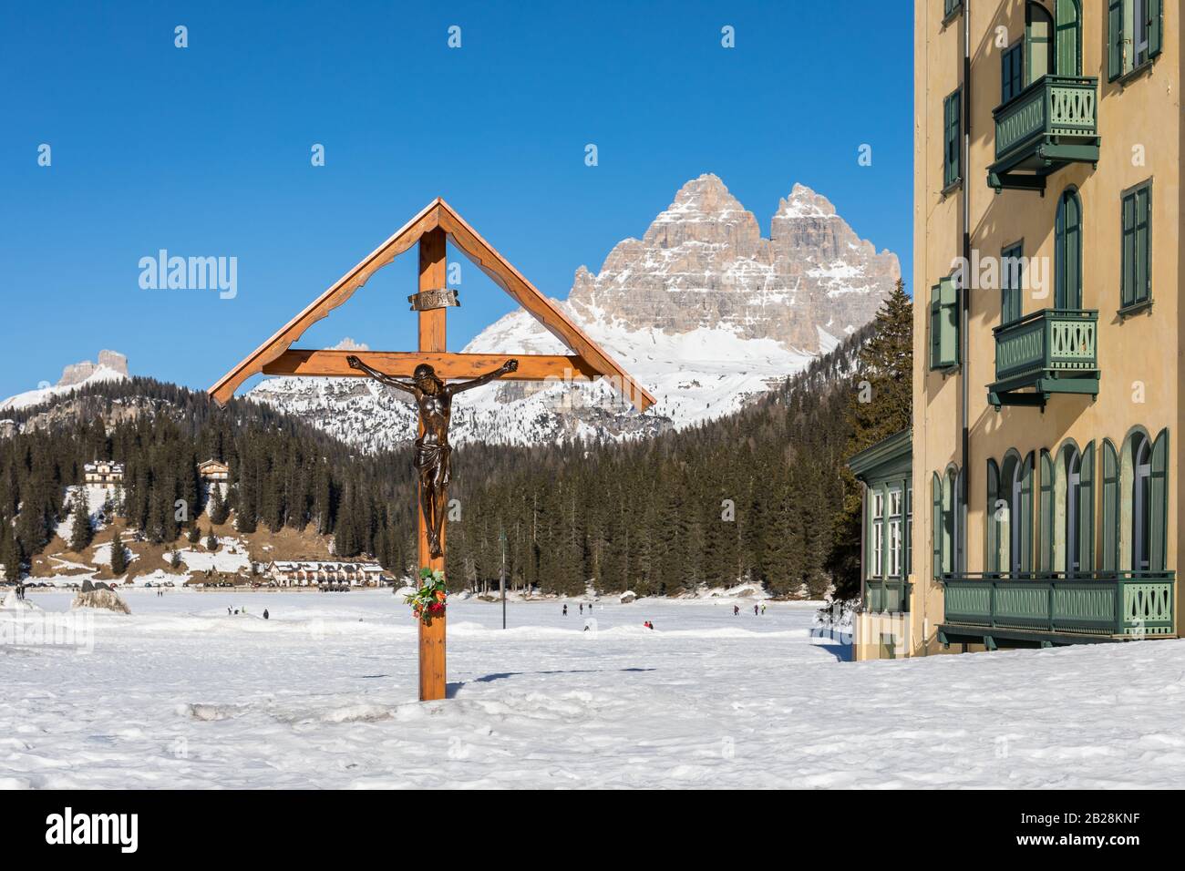 Croce crocifisso in legno con il Lago della Misurina ghiacciato e le tre Cime di Lavaredo sullo sfondo - Misurina, Dolomiti, Veneto, Italia Foto Stock