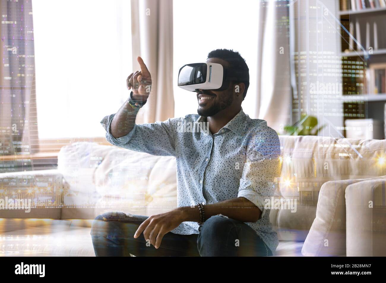 Giovane afroamericano eccitato indossando occhiali di realtà virtuale. Foto Stock