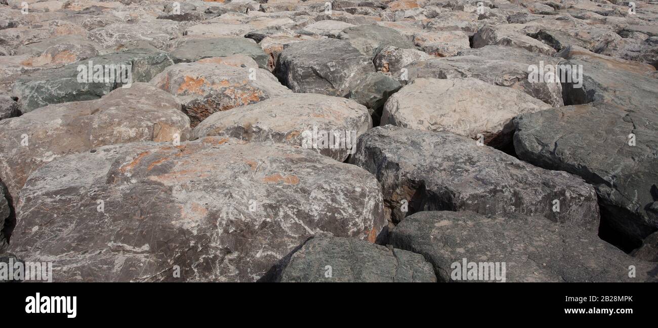 grandi rocce di bloulder vicino al mare per la protezione della riva Foto Stock