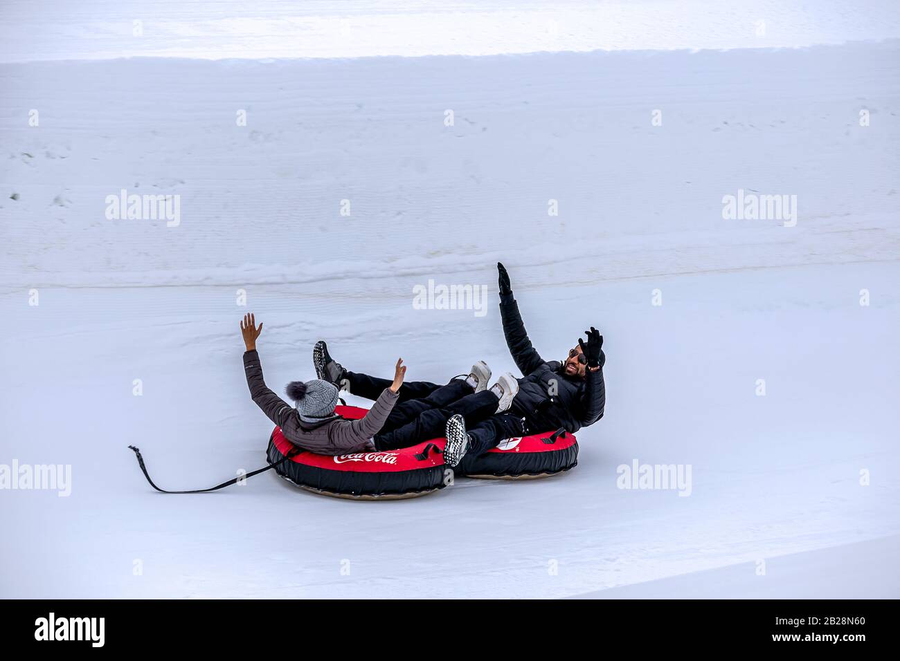 Winter Park, Colorado - 22 febbraio 2020 - una coppia che scivola lungo la collina su slitte trainate Foto Stock