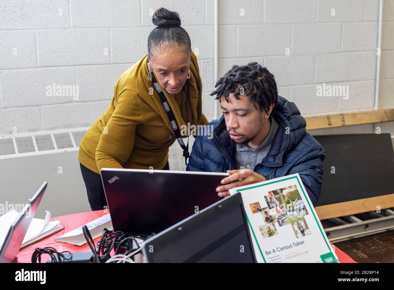 Detroit, Michigan, Stati Uniti. 1st Mar, 2020. Juanita Brown (in piedi), un reclutatore di lavoro censimento, aiuta un giovane uomo a fare domanda per un lavoro con Il Censimento degli Stati Uniti durante una fiera di lavoro a Martin Evers Missionario Battista Chiesa. Credito: Jim West/Alamy Live News Foto Stock