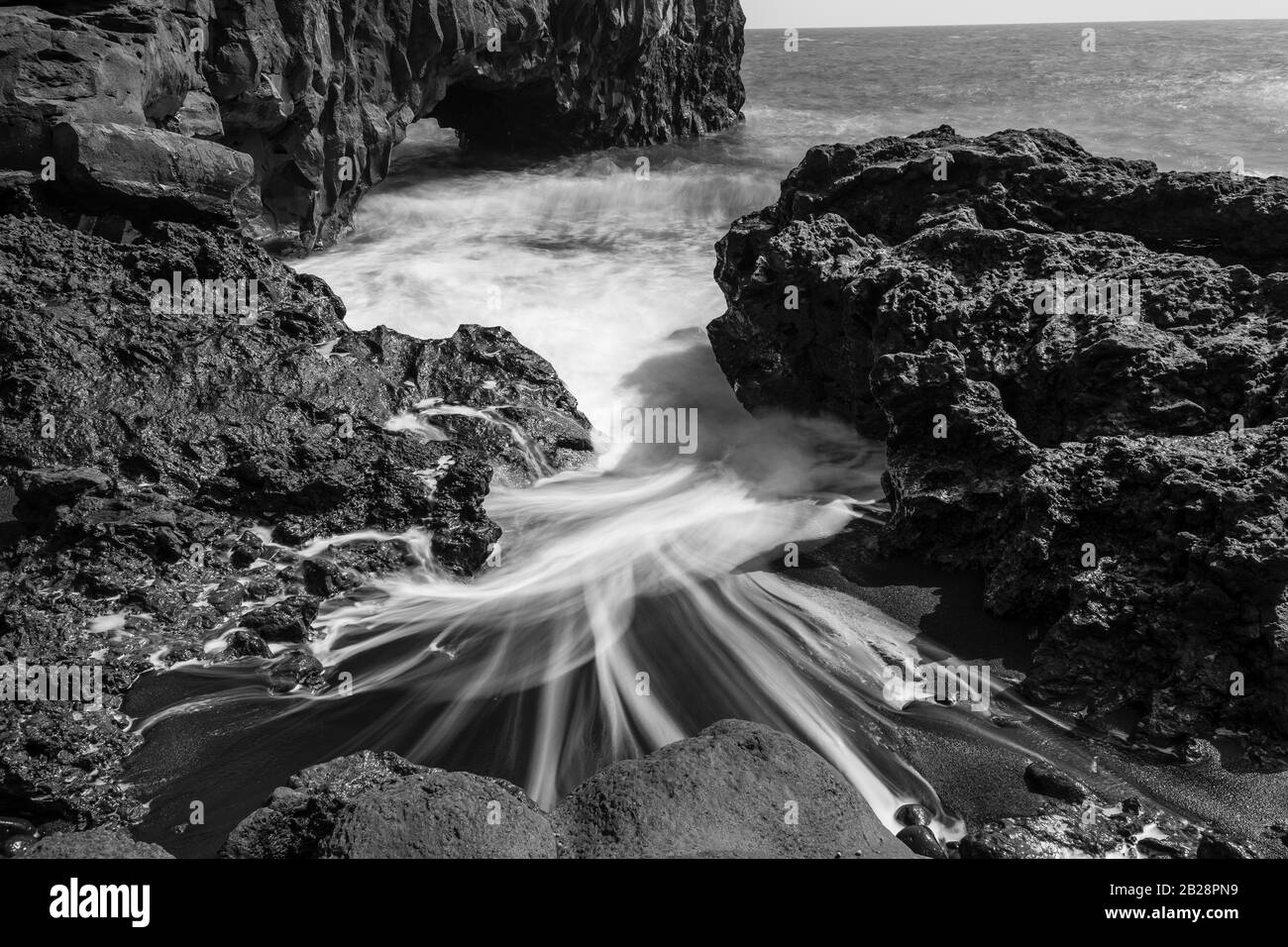 L'acqua si lava intorno a pietre, sabbia nera lavica, spiaggia, bianco e nero, la Palma, Isole Canarie, Isole Canarie, Spagna Foto Stock