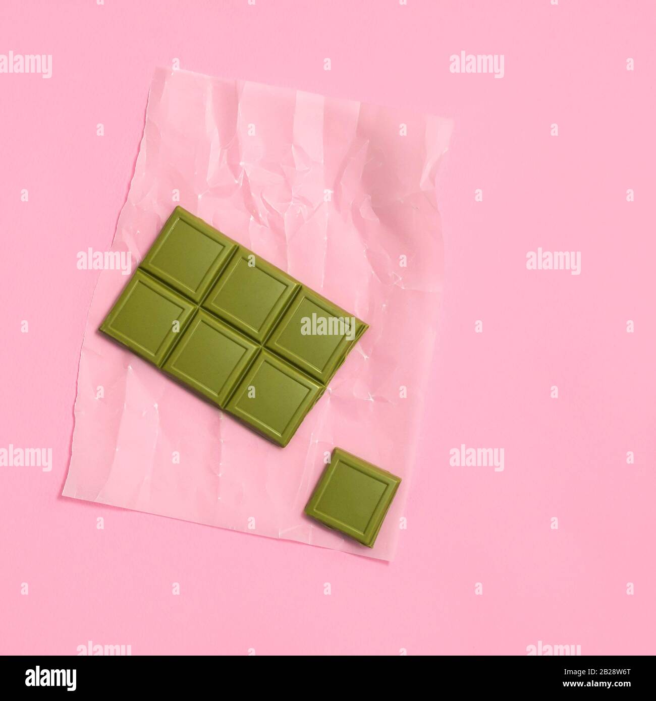 Vegan basso cioccolato bianco matcha color carb su sfondo rosa pastello, vista dall'alto Foto Stock