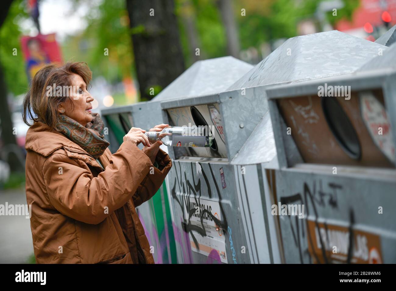 Gestelltes Foto, Seniorin, Altglascontainer, Glasrecycling Foto Stock