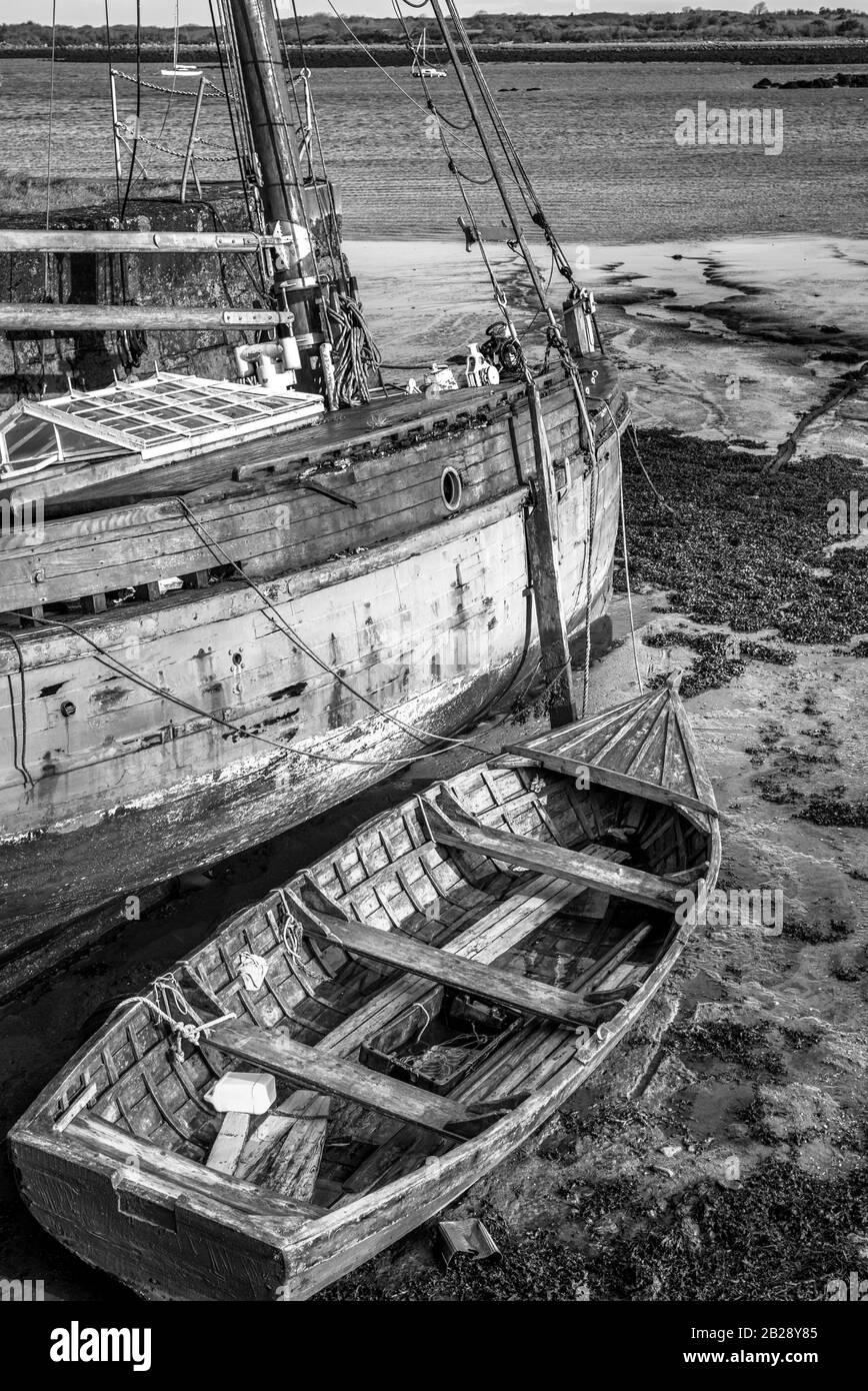 Due vecchie barche di legno a bassa marea sulla costa occidentale dell'Irlanda Foto Stock