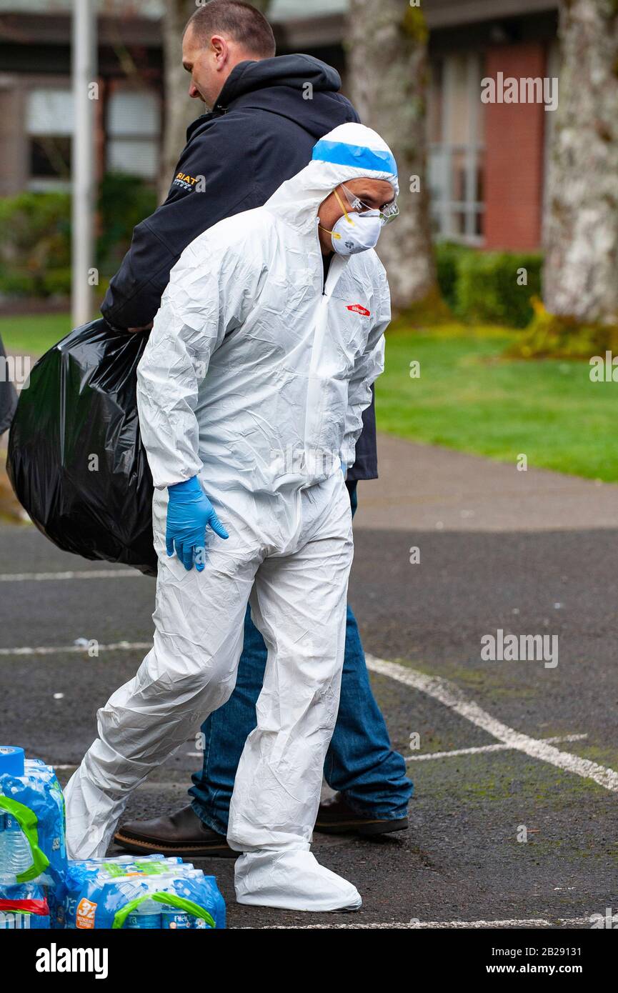 I lavoratori indossano indumenti protettivi e maschere prima di entrare nella Forest Hills Elementary School di Lake Oswego, Oregon. Le autorità sanitarie dell'Oregon hanno identificato un membro dello staff scolastico come avente un test positivo del COVID-19 Ccoronavirus, verificato dai Centri per il controllo Delle Malattie di Atlanta. Lake Oswego School District Superentendent, Dr. Lora de la Cruz ha dichiarato che la 'pulizia di ep' della scuola è in corso di azioni precauzionali. Foto Stock