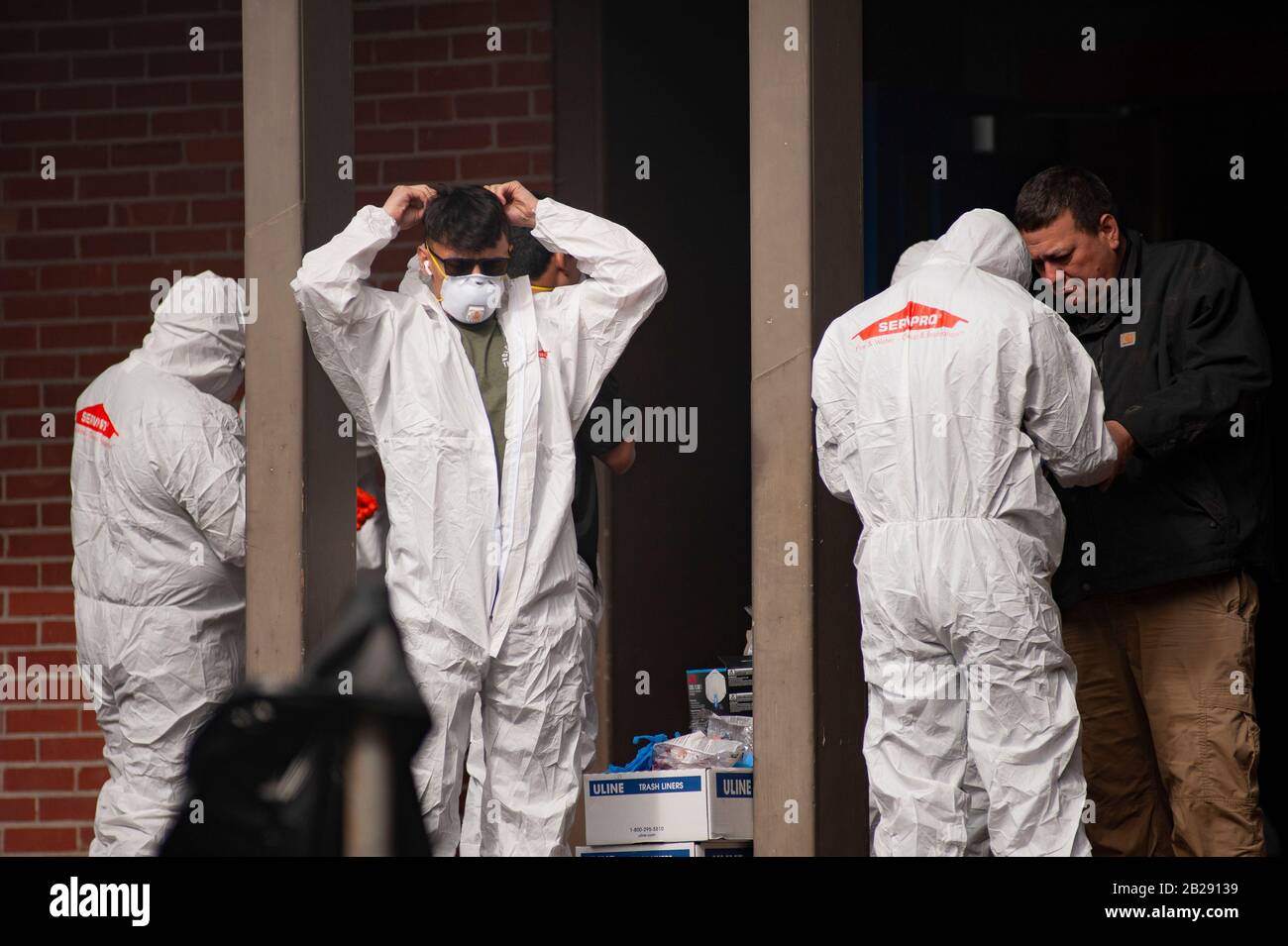 I lavoratori indossano indumenti protettivi e maschere prima di entrare nella Forest Hills Elementary School di Lake Oswego, Oregon. Le autorità sanitarie dell'Oregon hanno identificato un membro dello staff scolastico come avente un test positivo del COVID-19 Ccoronavirus, verificato dai Centri per il controllo Delle Malattie di Atlanta. Lake Oswego School District Superentendent, Dr. Lora de la Cruz ha dichiarato che la 'pulizia di ep' della scuola è in corso di azioni precauzionali. Foto Stock