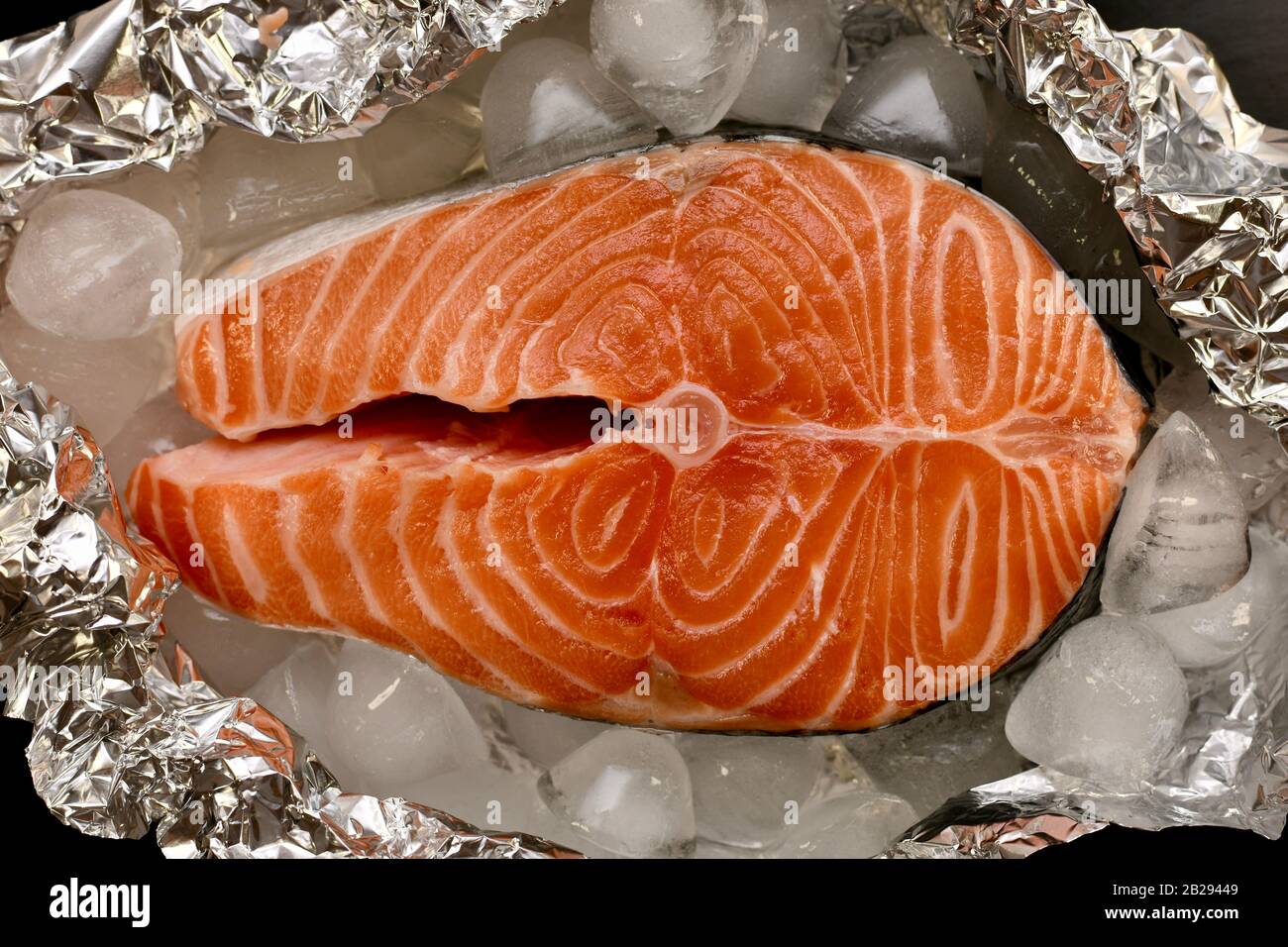 Bistecca di salmone rosa in un taglio trasversale sulla lamina tra il ghiaccio. Foto Stock